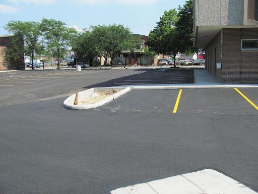 A parking lot with a brick building in the background