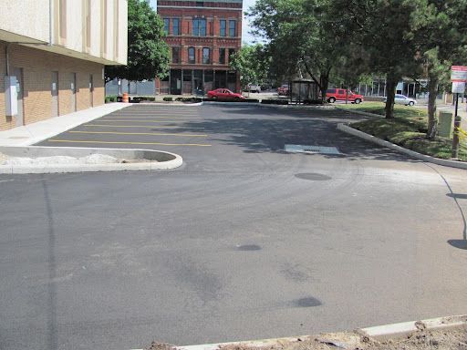 A parking lot with a brick building in the background