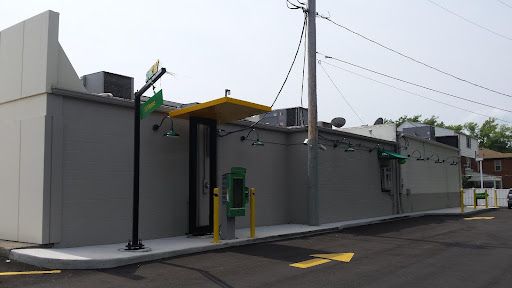 A building with a green phone booth on the side of it.