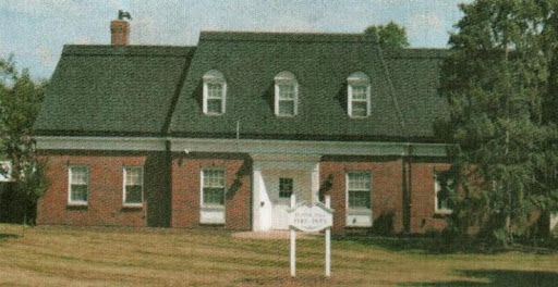 A large brick house with a sign in front of it