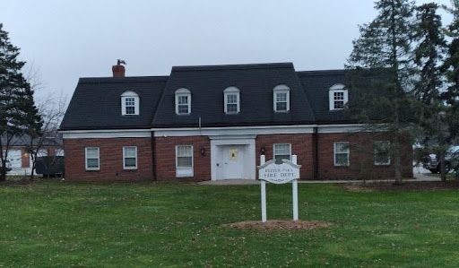 A large brick house with a sign in front of it.
