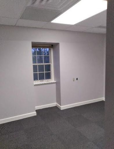 An empty room with a window and a ceiling light.