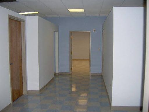 An empty hallway with a checkered floor and white walls