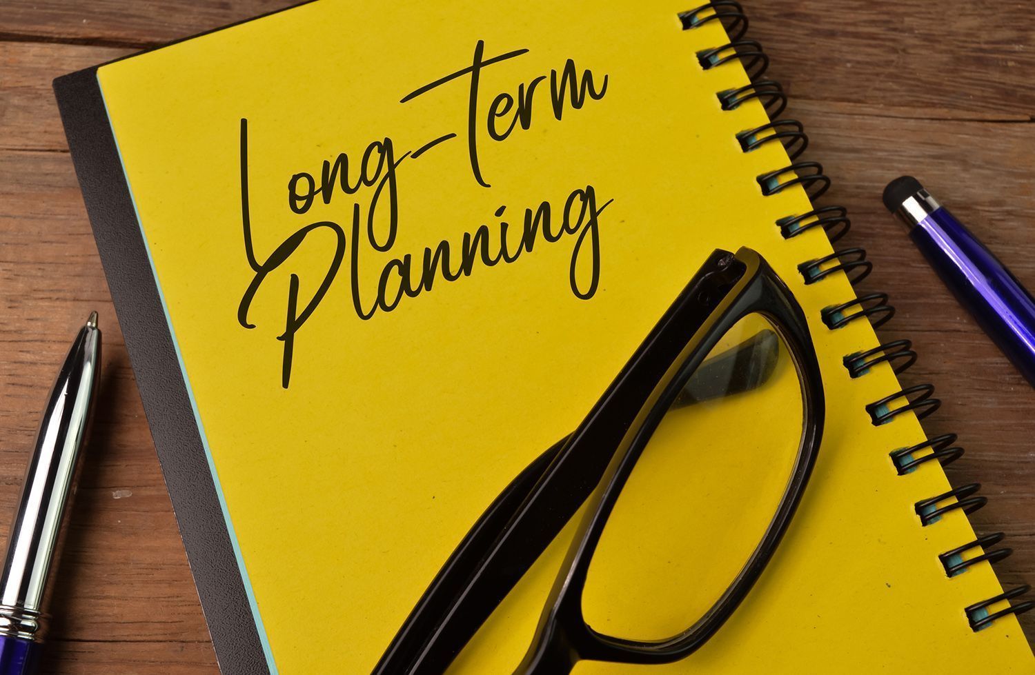 A yellow notebook with long-term planning written on it