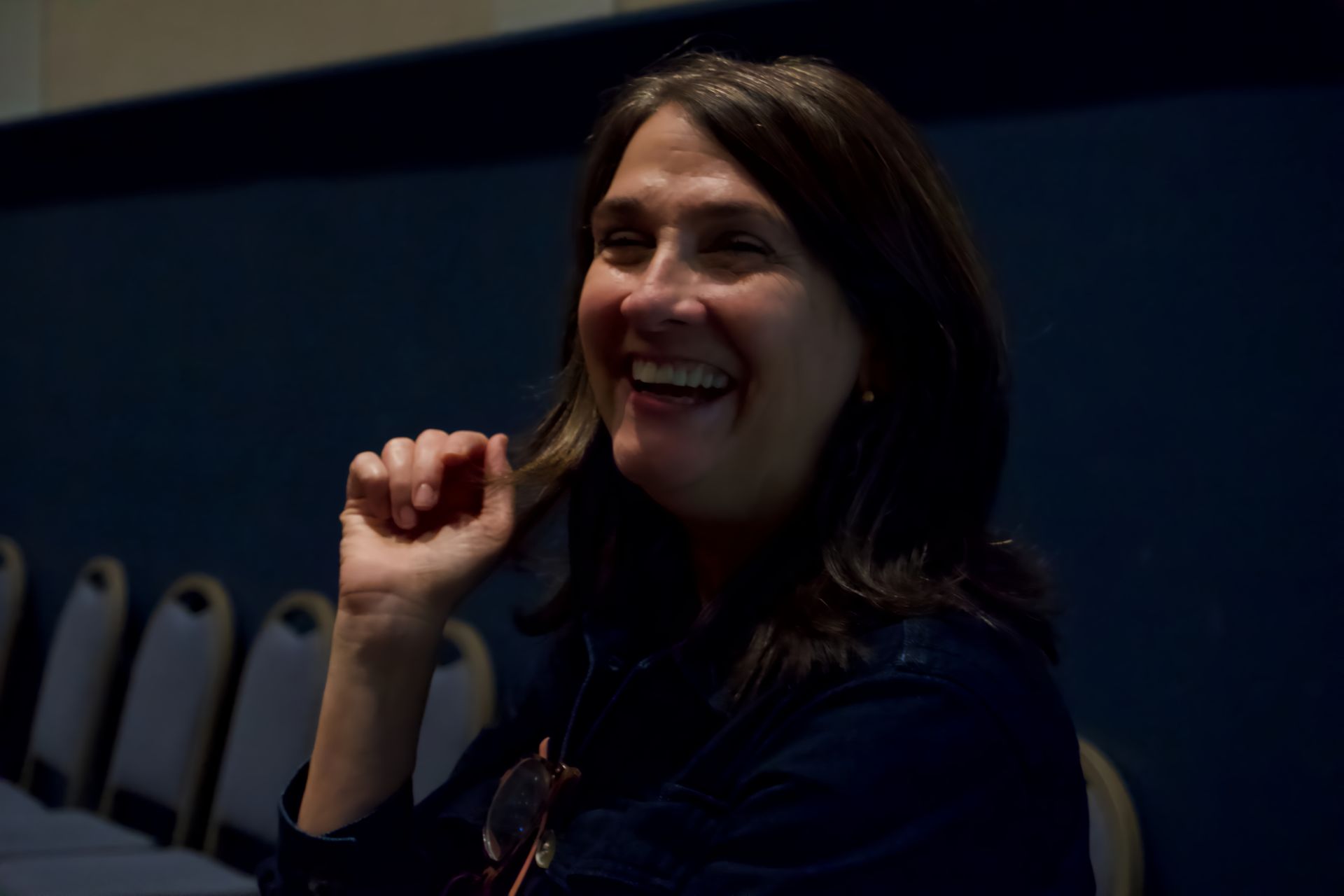 A woman is smiling with her hand on her chin