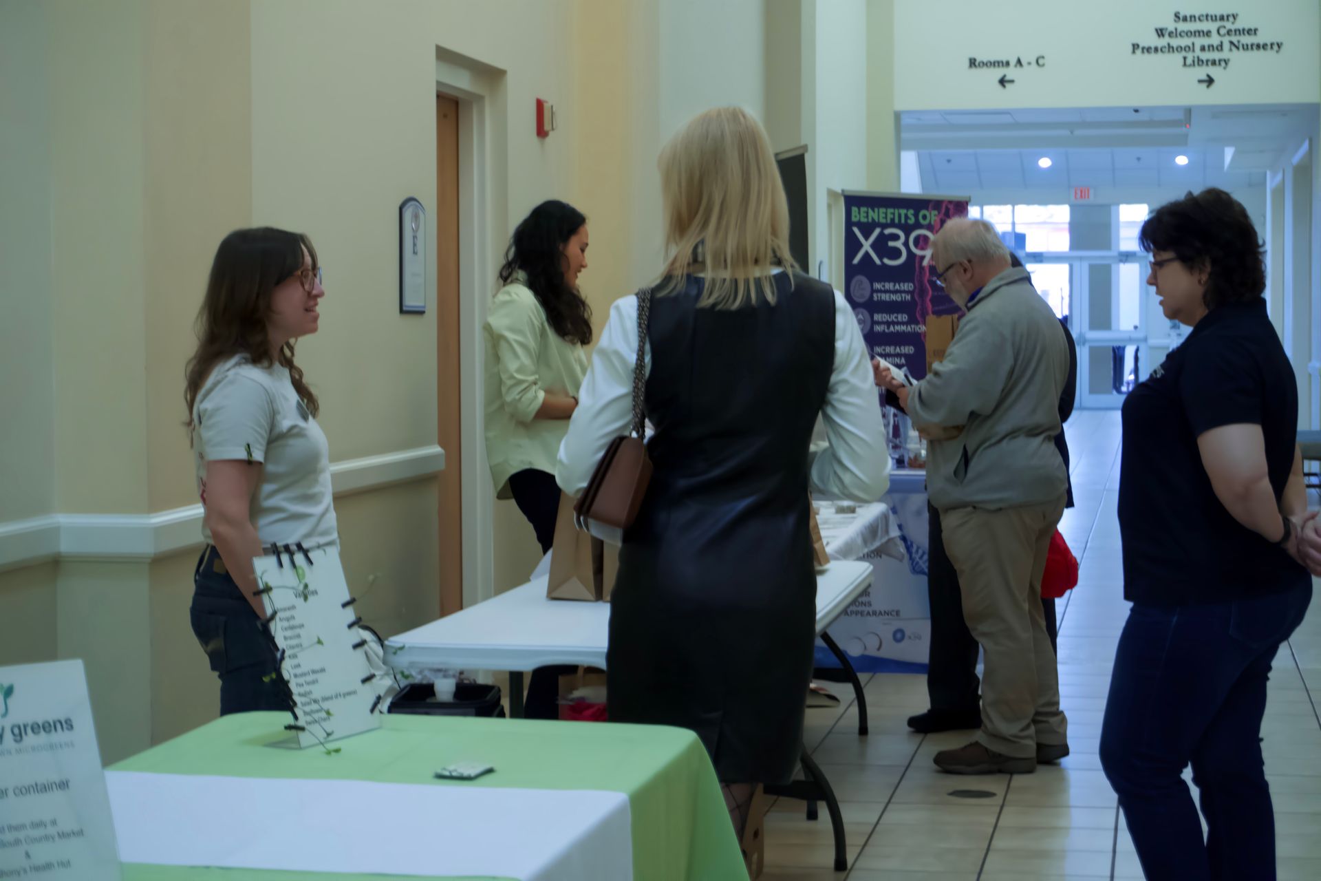 A group of people standing around a table with a sign that says x39 on it