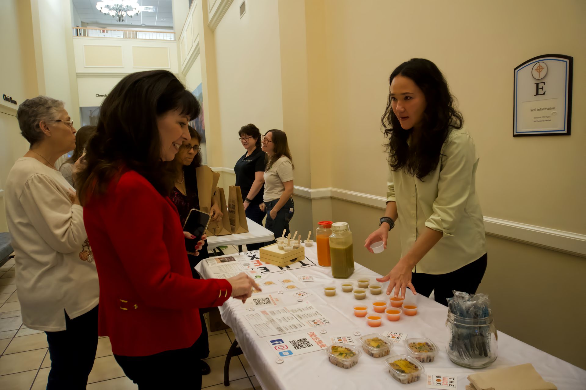 A group of women are standing around a table.