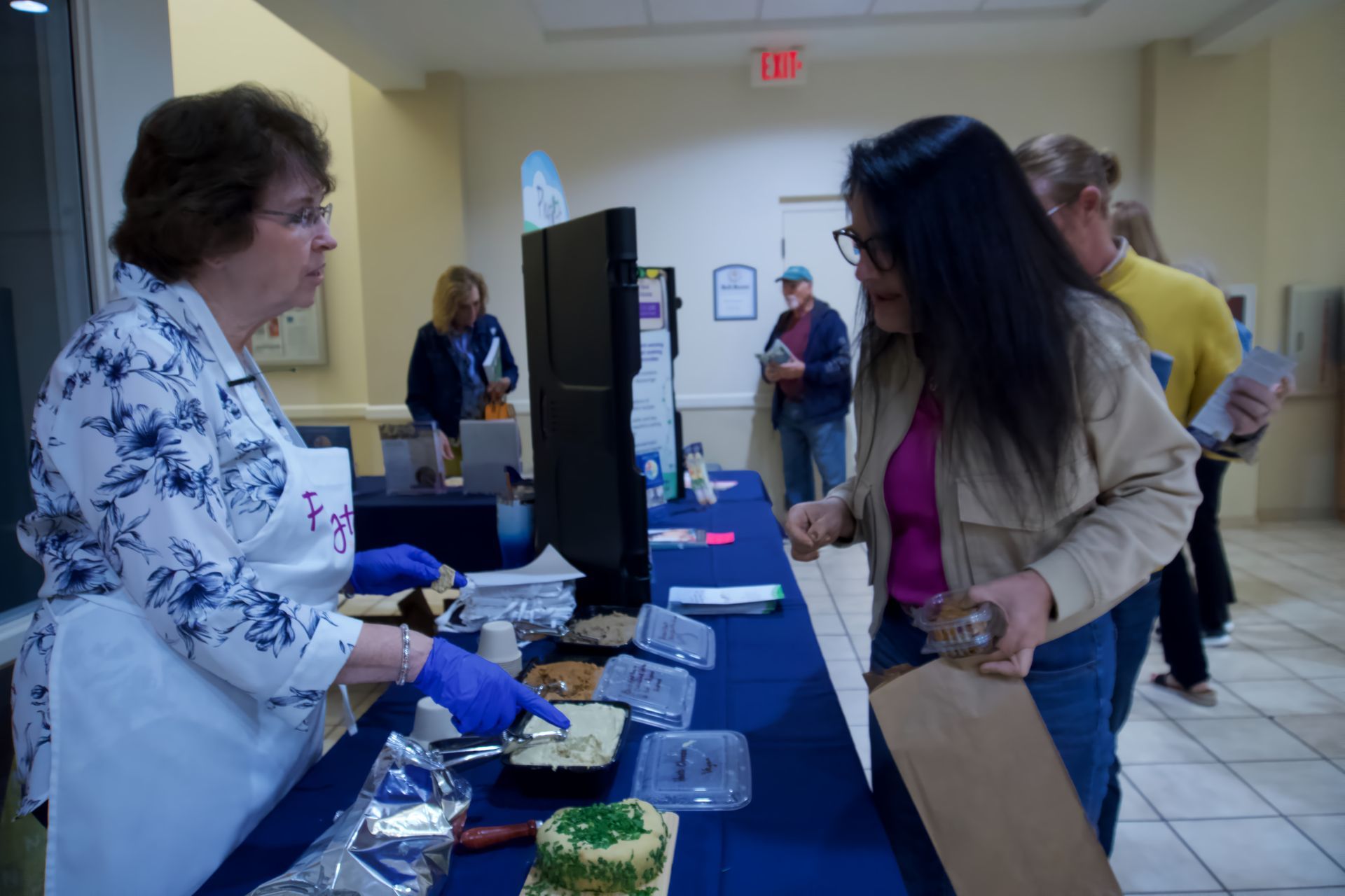 A woman is serving food to a woman at a table.