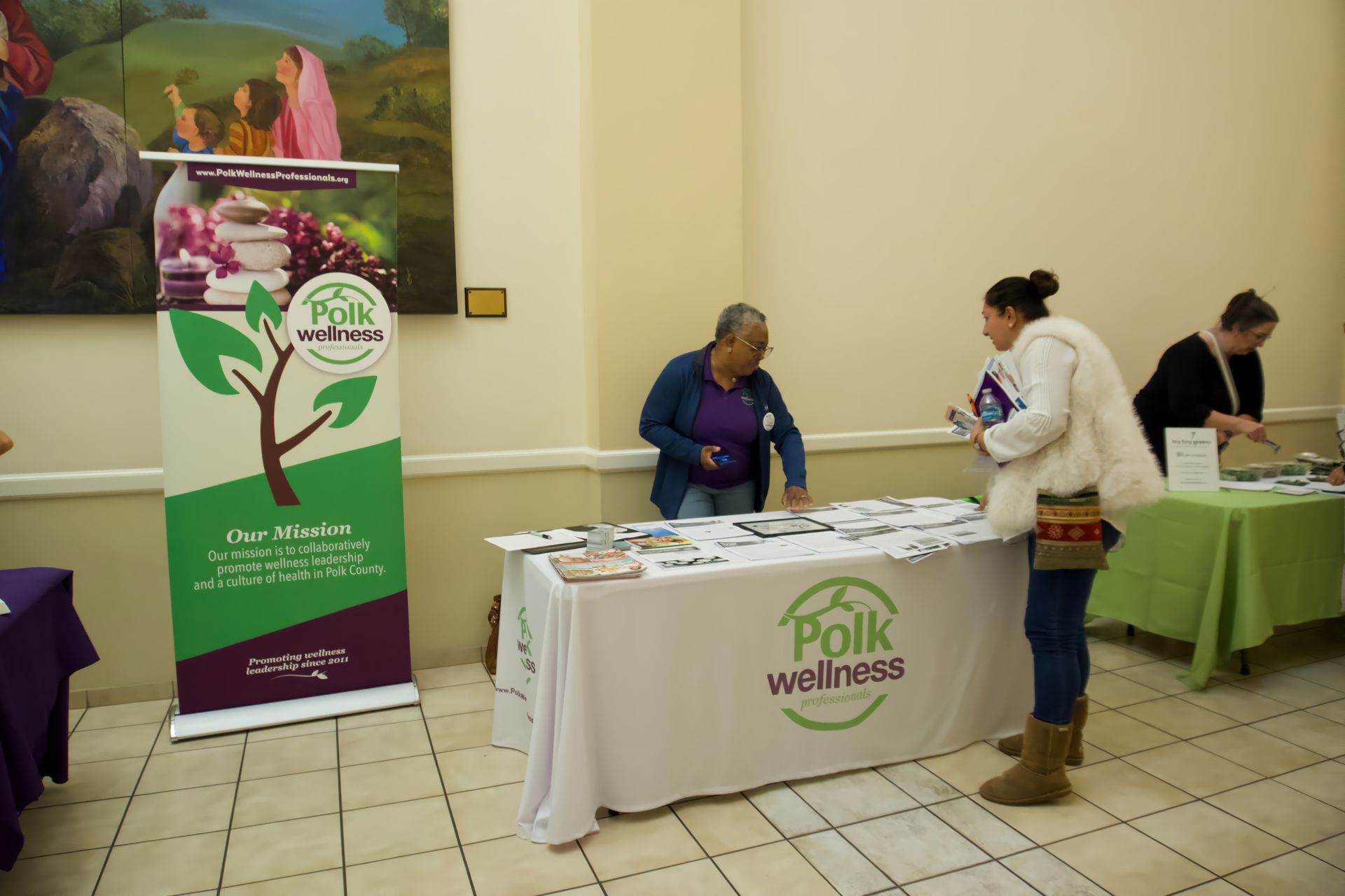 A group of people standing around a table that says polk wellness