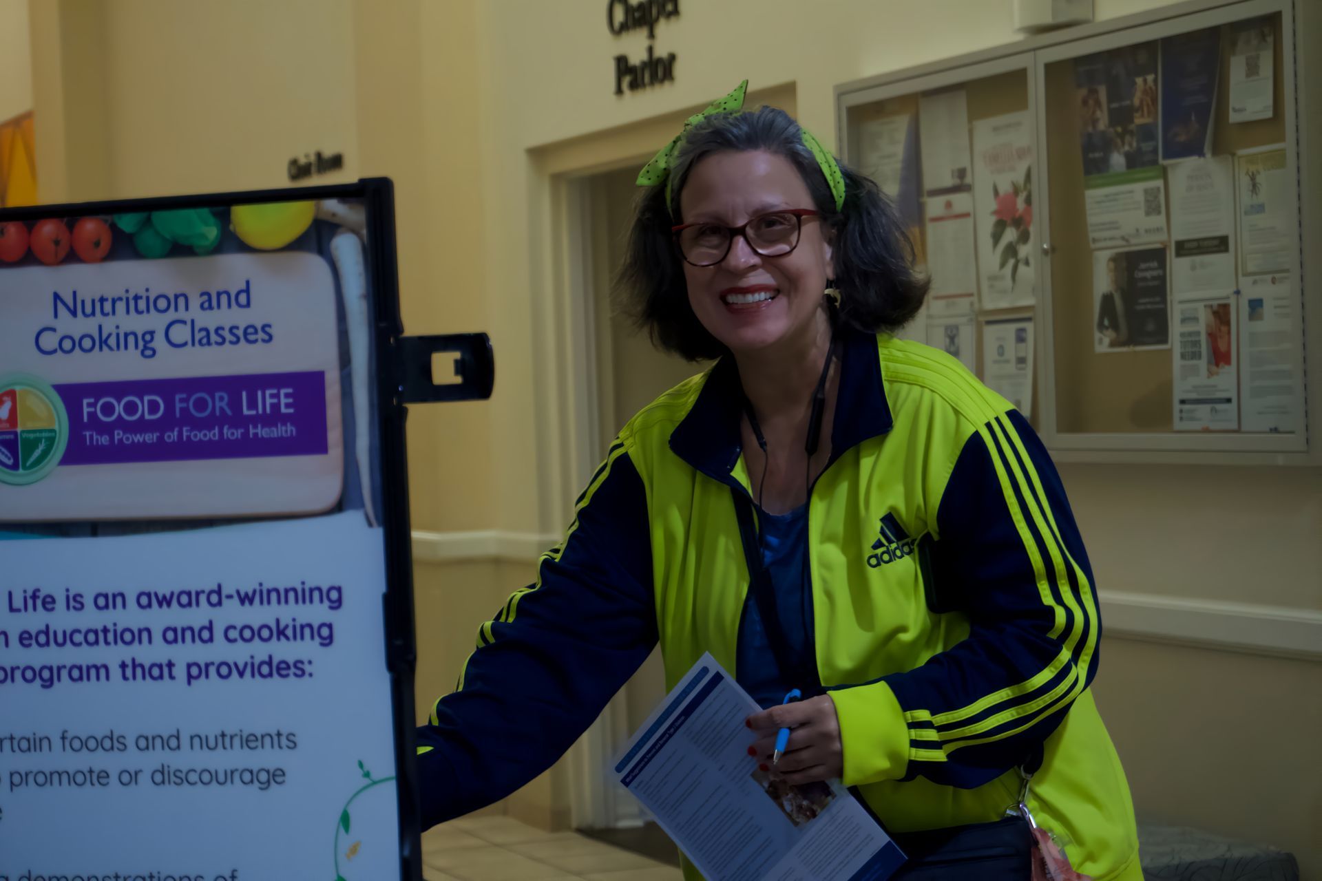 A woman is standing in front of a sign that says food for life