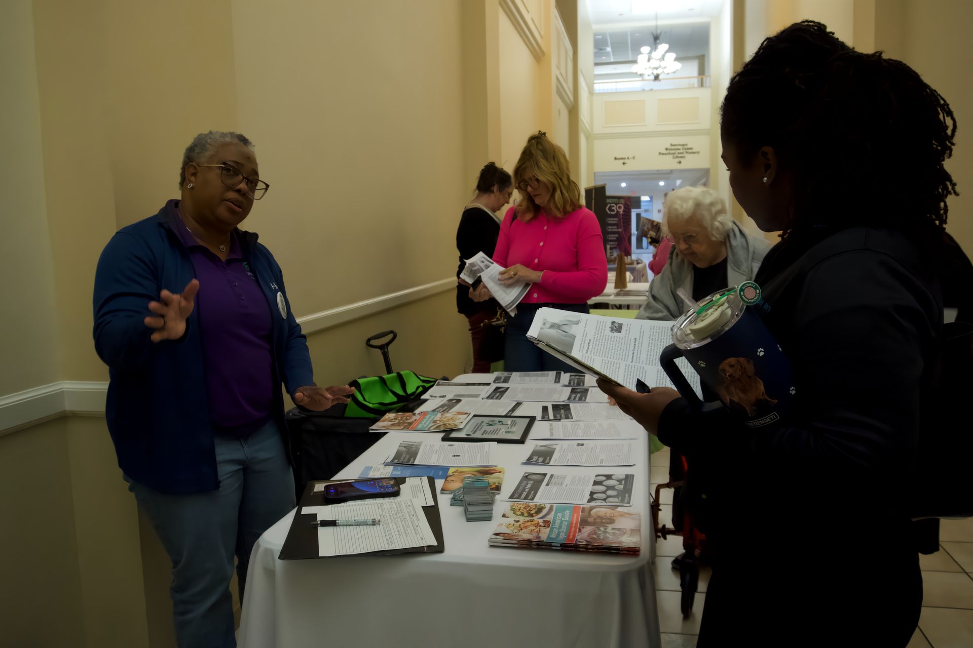 A group of people are standing around a table with papers on it.