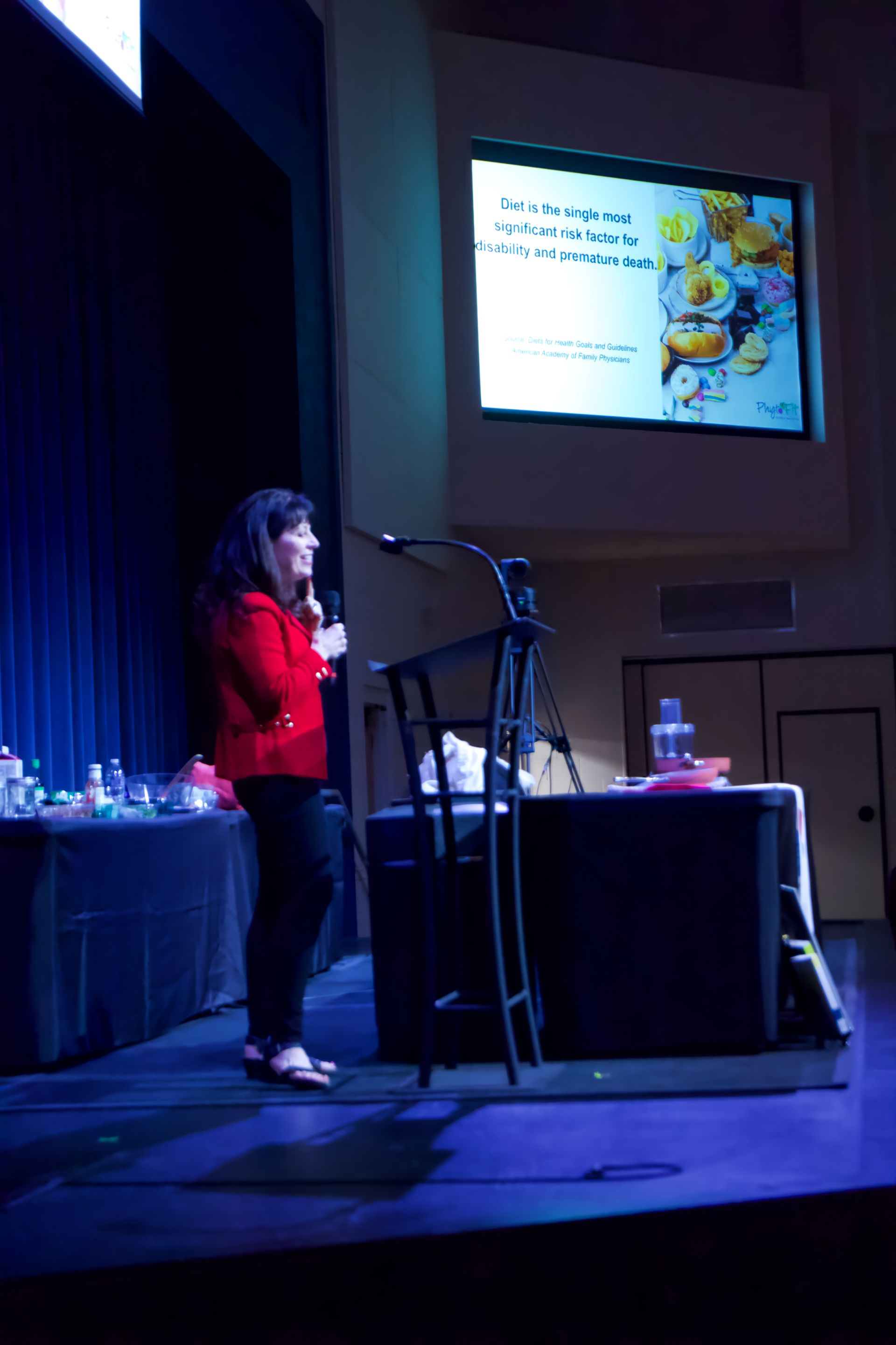 A woman is giving a presentation in front of a large screen