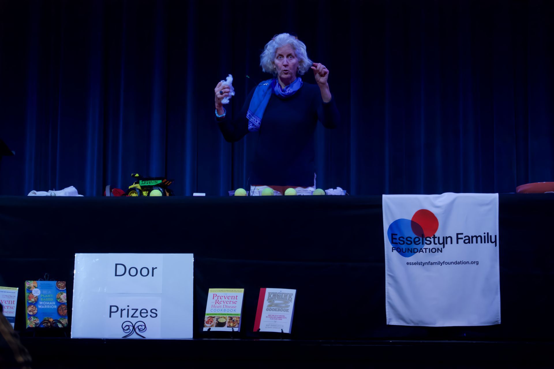 A woman is standing in front of a sign that says door prizes