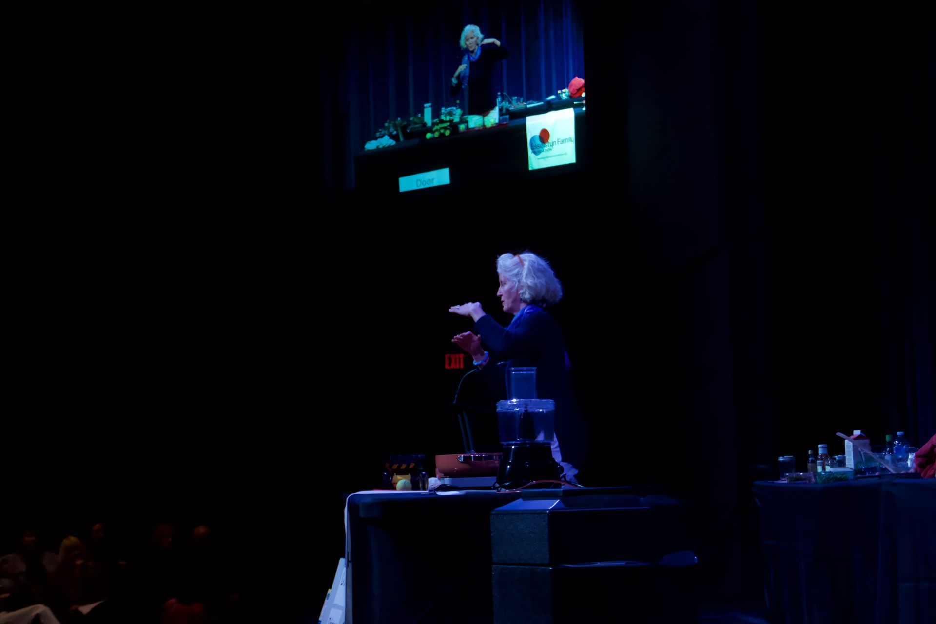 A woman is standing on a stage with a microphone in her hand.