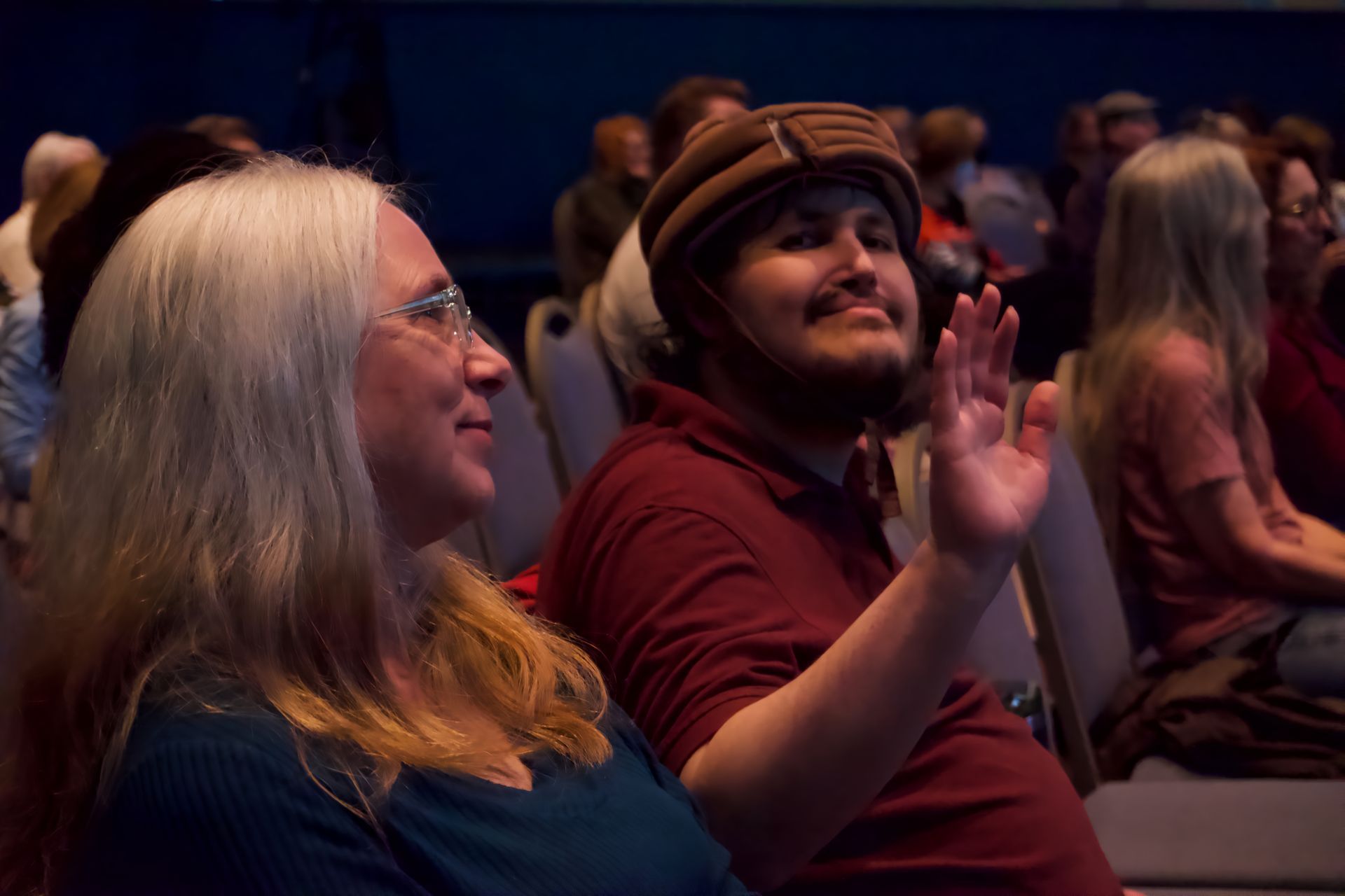 A man and a woman are sitting in a theater watching a movie.