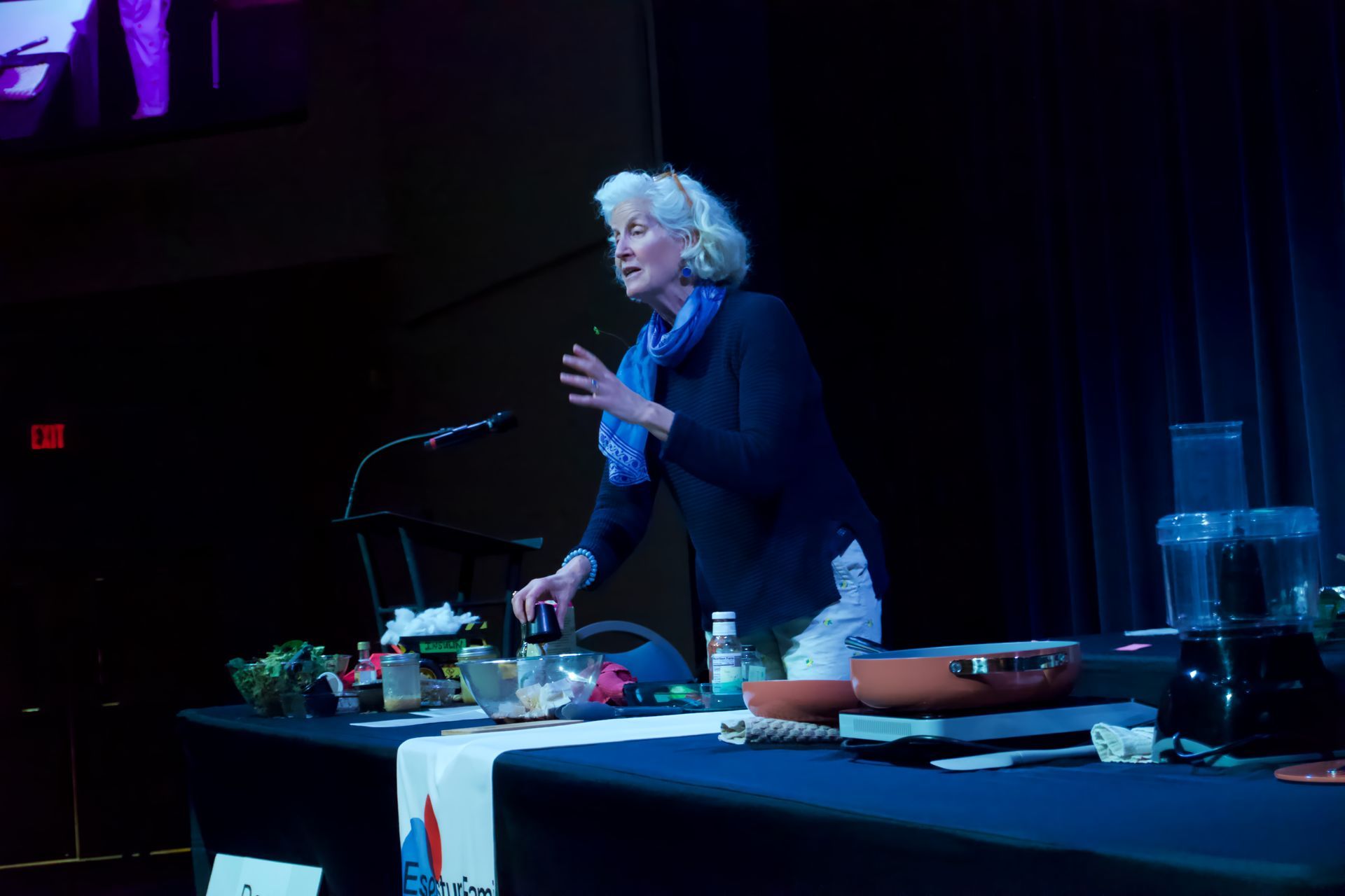 A woman is standing in front of a microphone on a stage