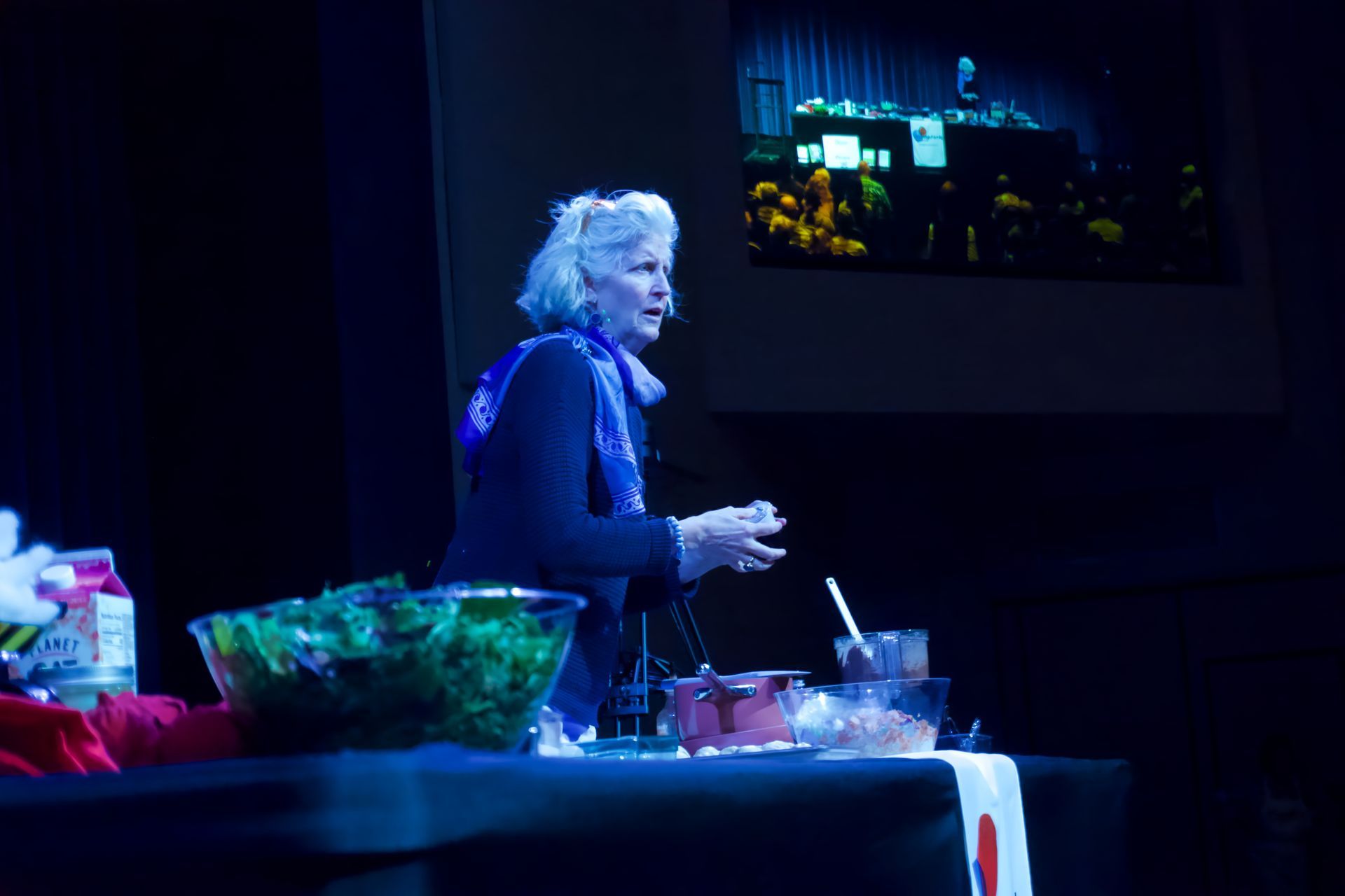 A woman is standing in front of a table with bowls of food on it.