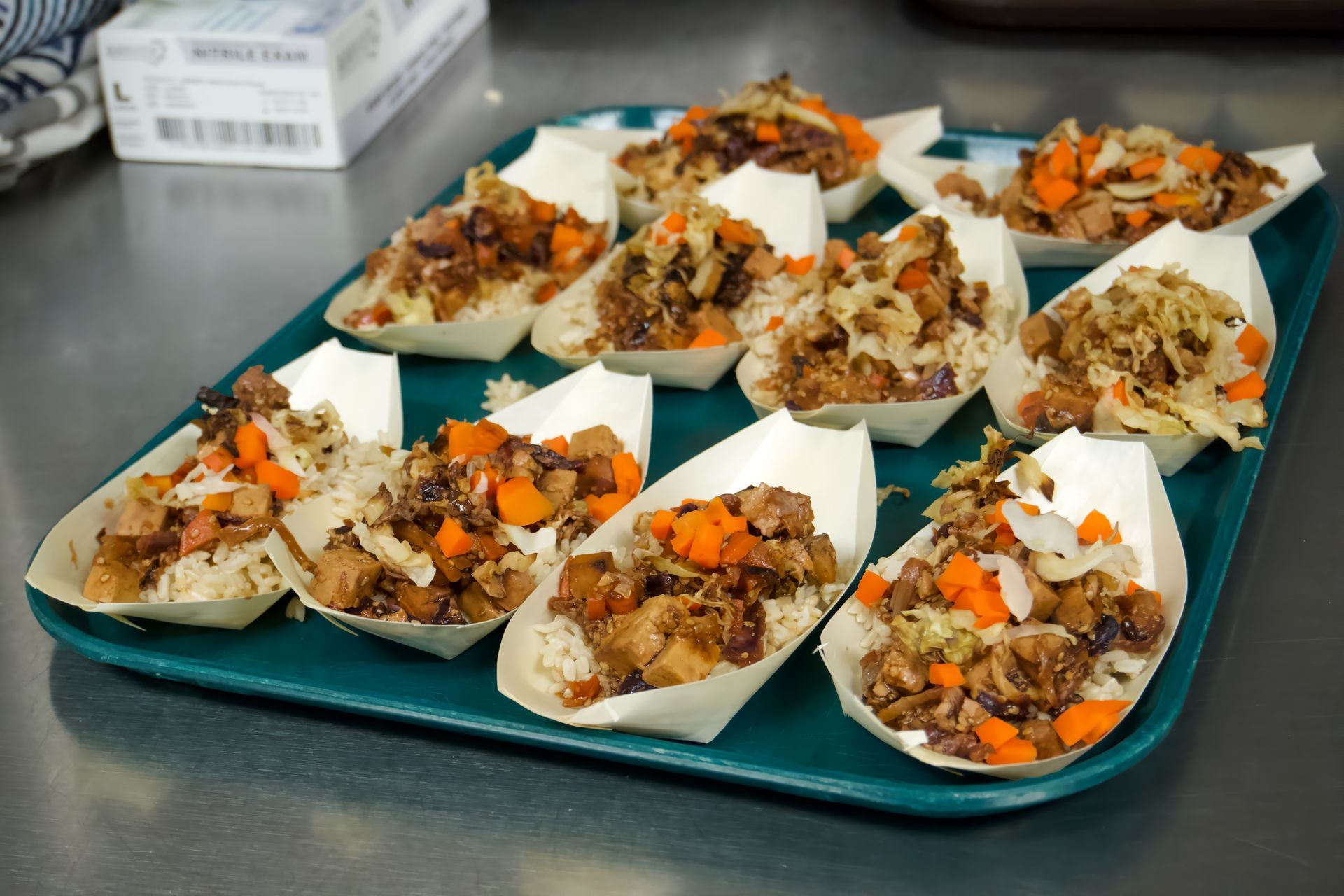 A tray filled with paper boats filled with food on a table.