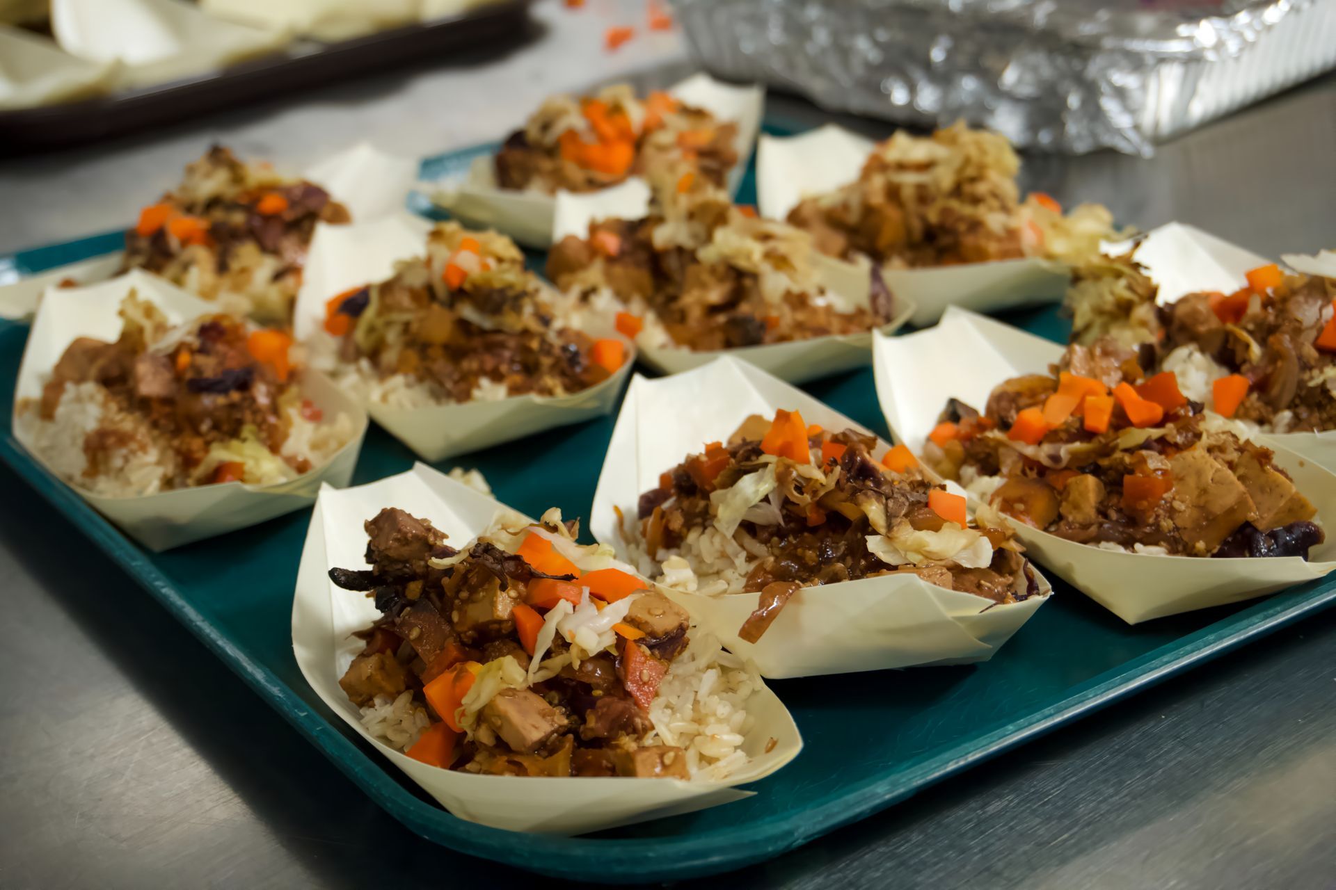 A tray of food in paper containers on a table.