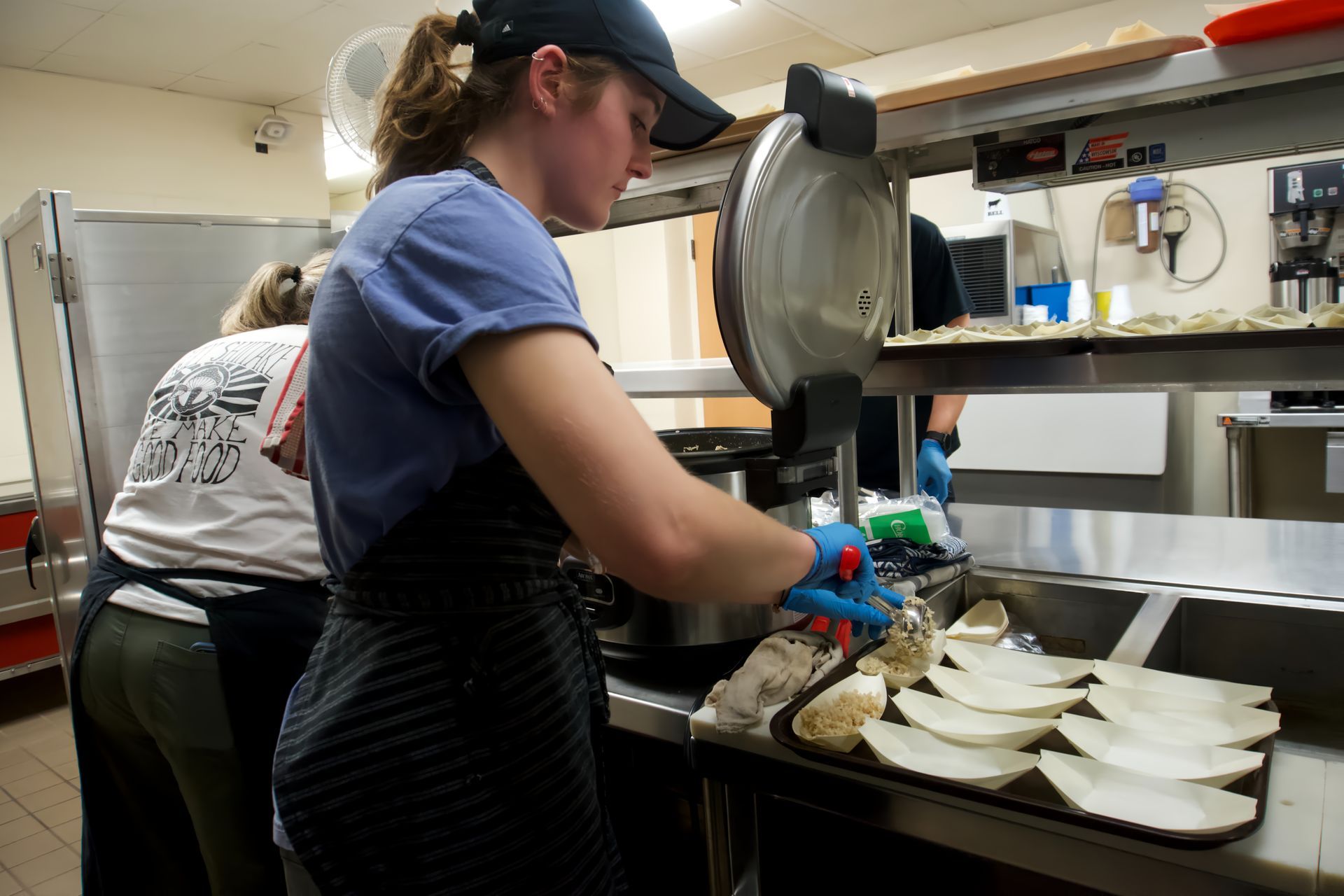 A woman is working in a kitchen preparing food.
