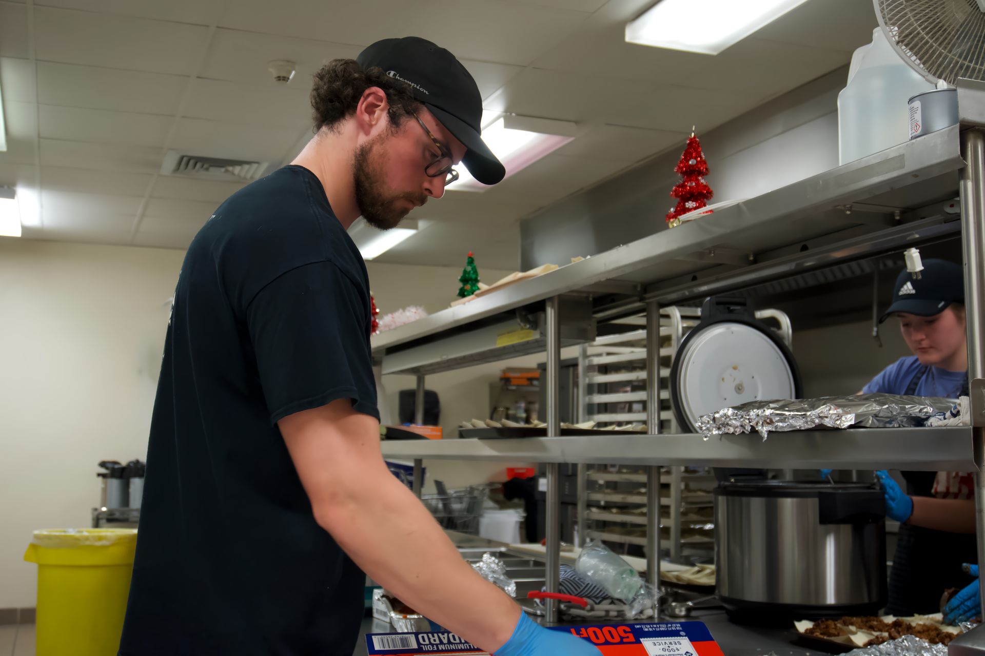 A man is standing in a kitchen preparing food.
