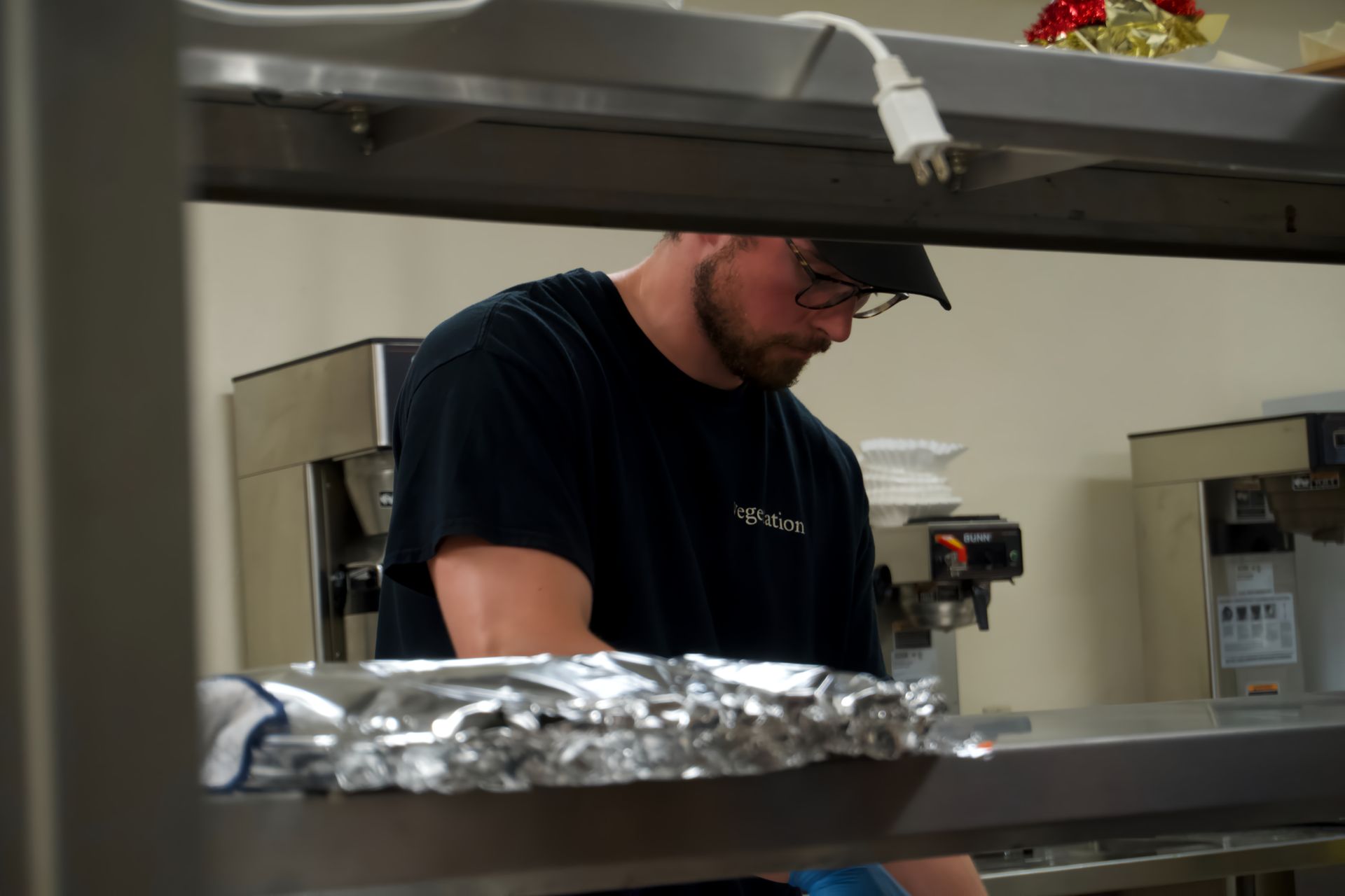 A man in a black shirt is working in a kitchen