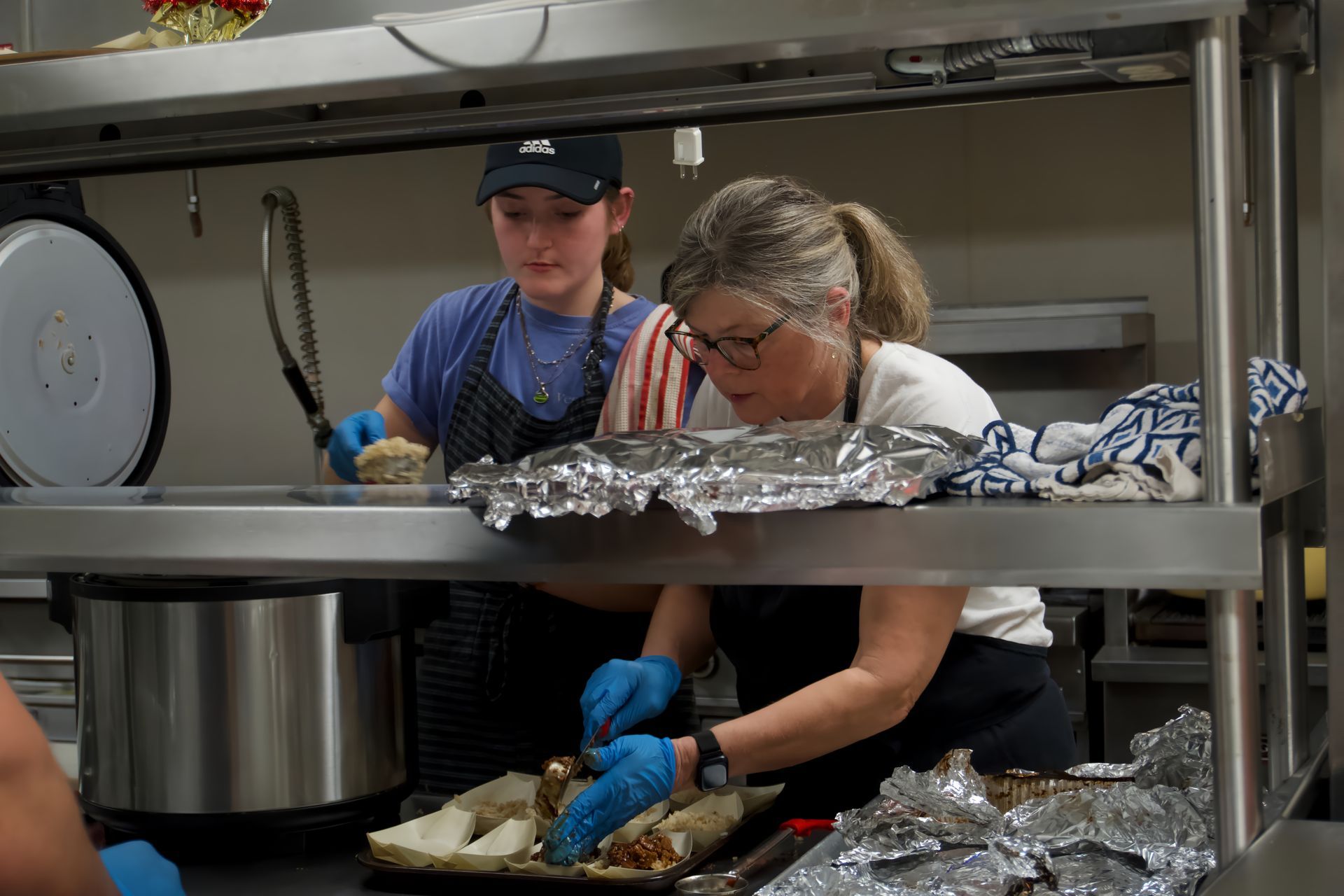 A woman and a boy are preparing food in a kitchen.