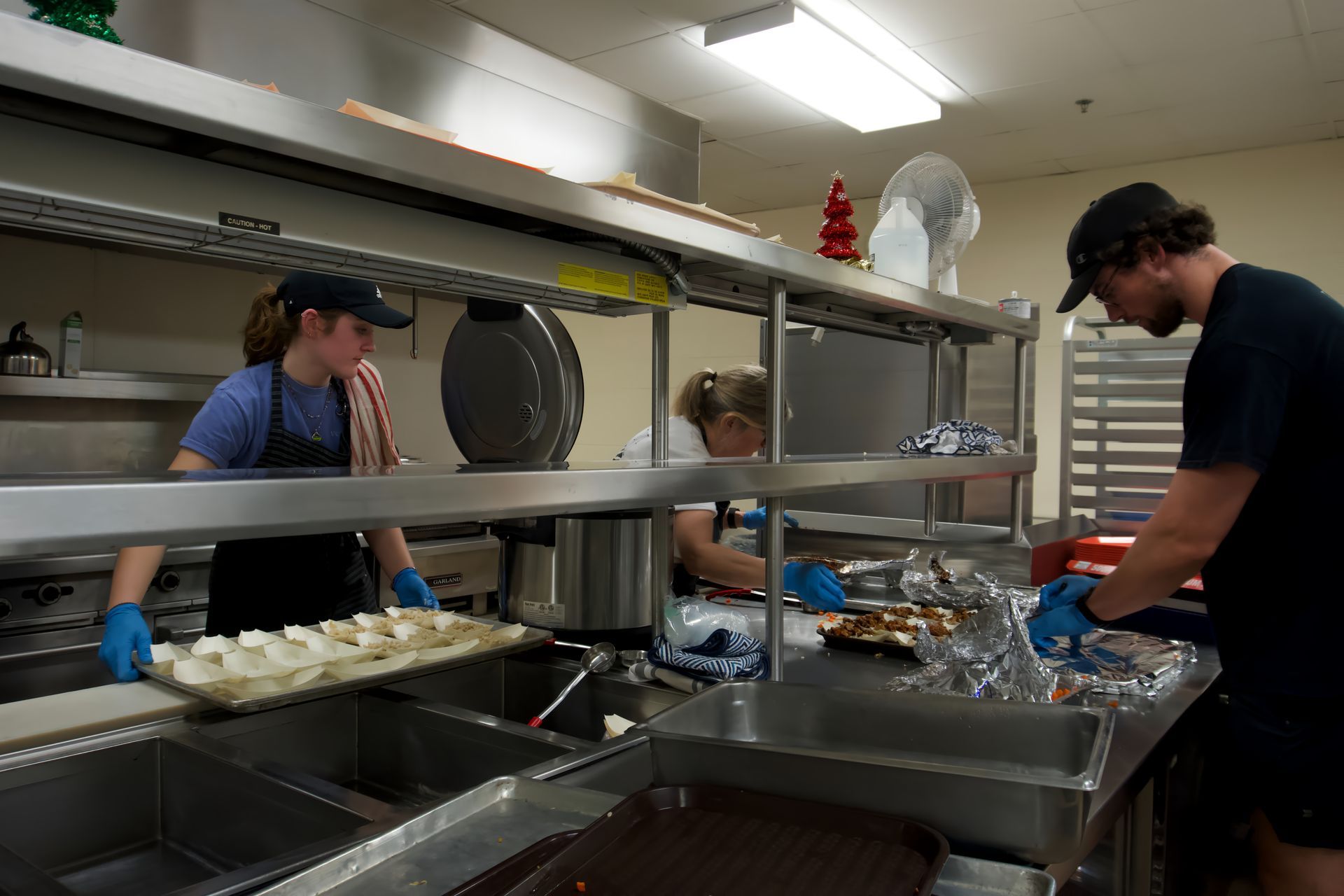 A group of people are working in a kitchen preparing food.