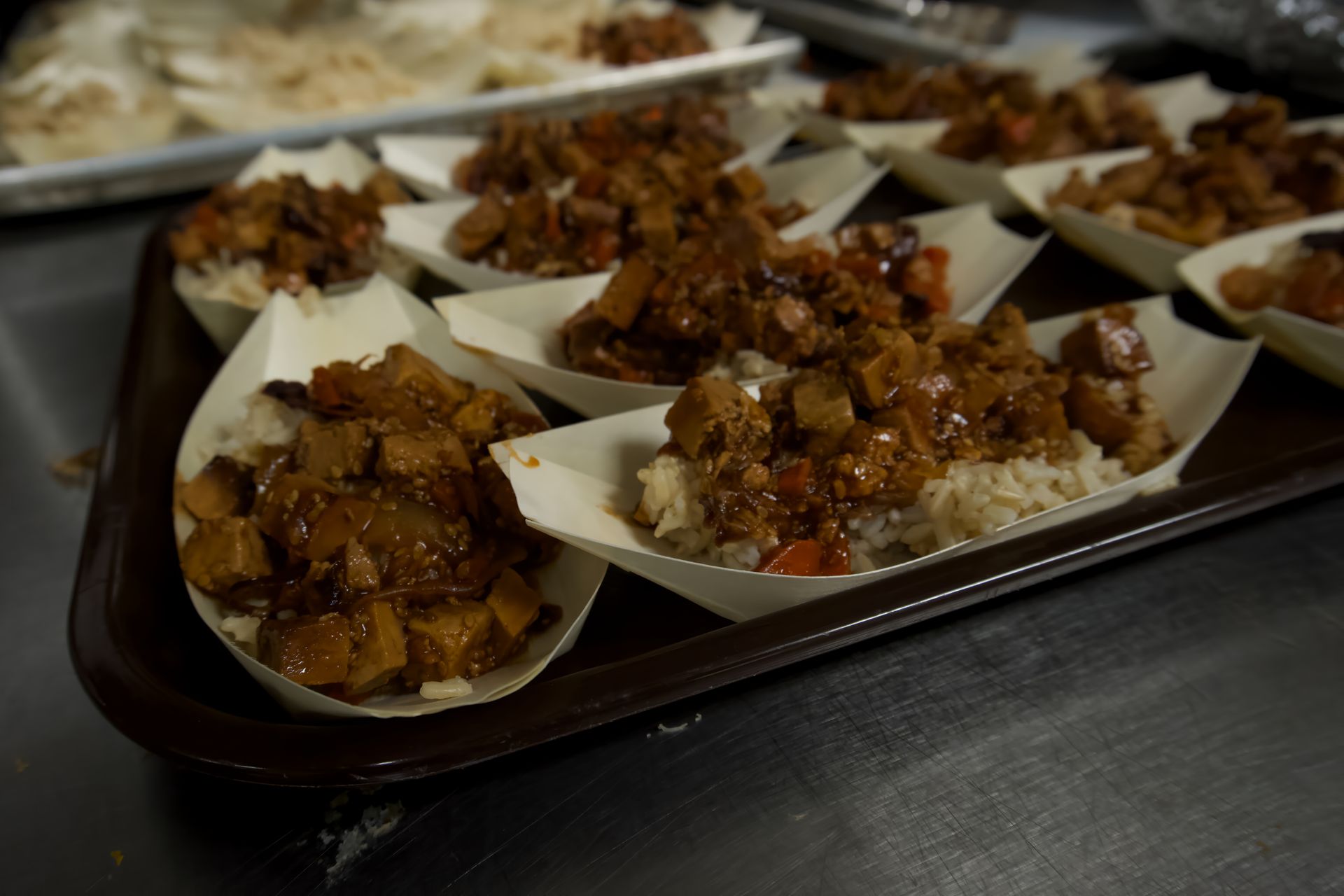 A tray of food in paper cups on a table.