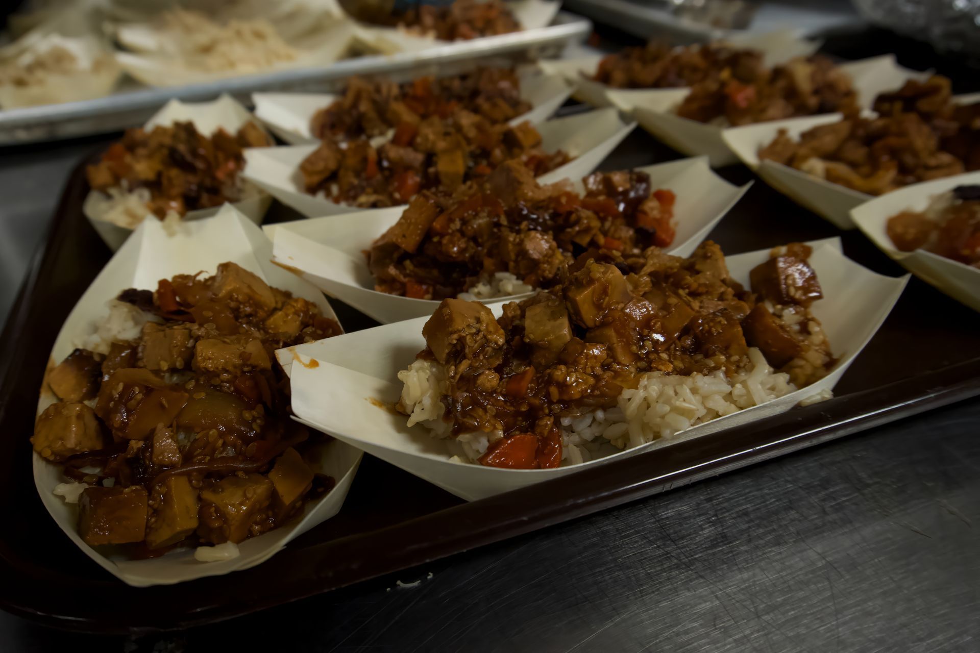 A tray of food in paper containers on a table.