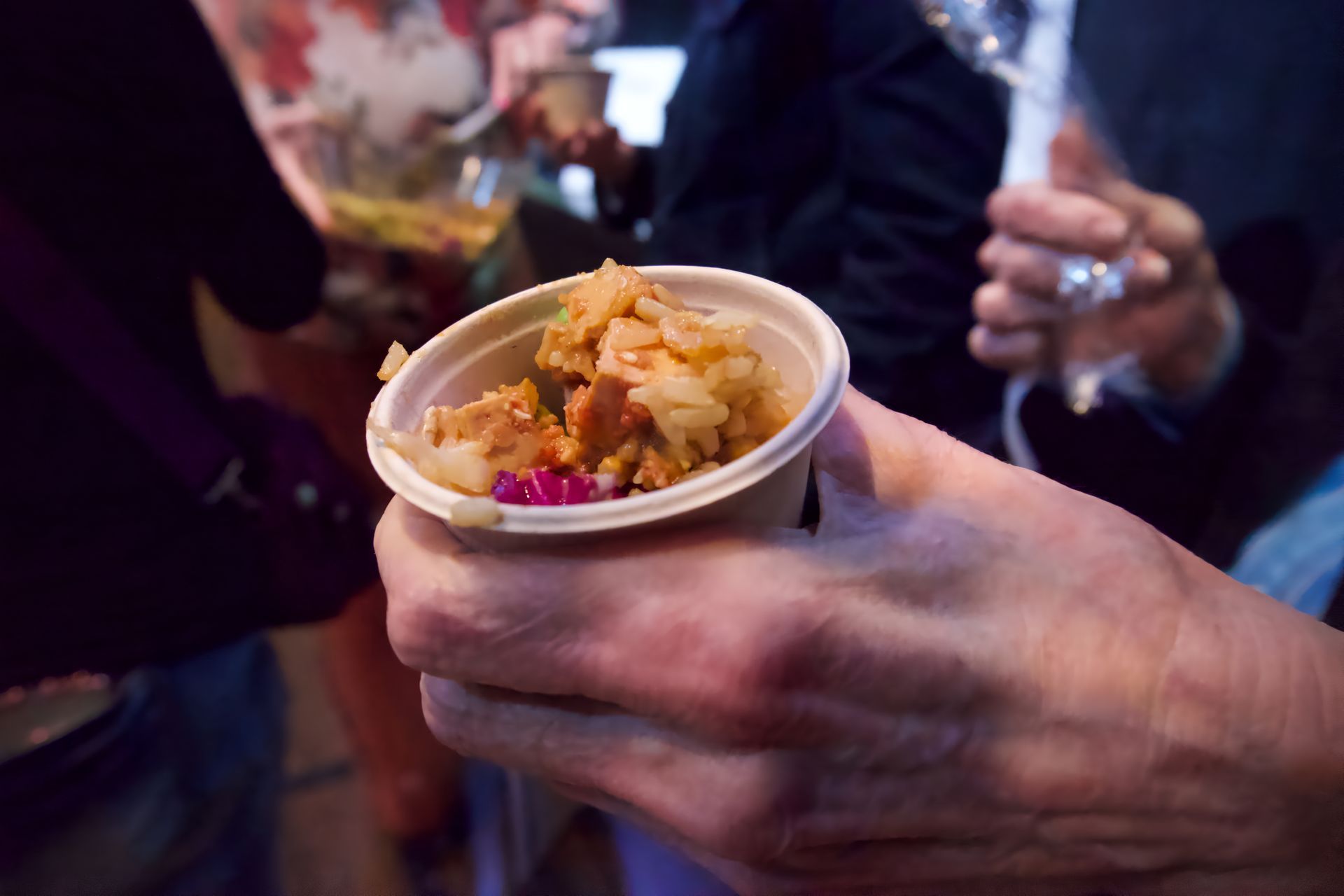 A person is holding a cup of food in their hand