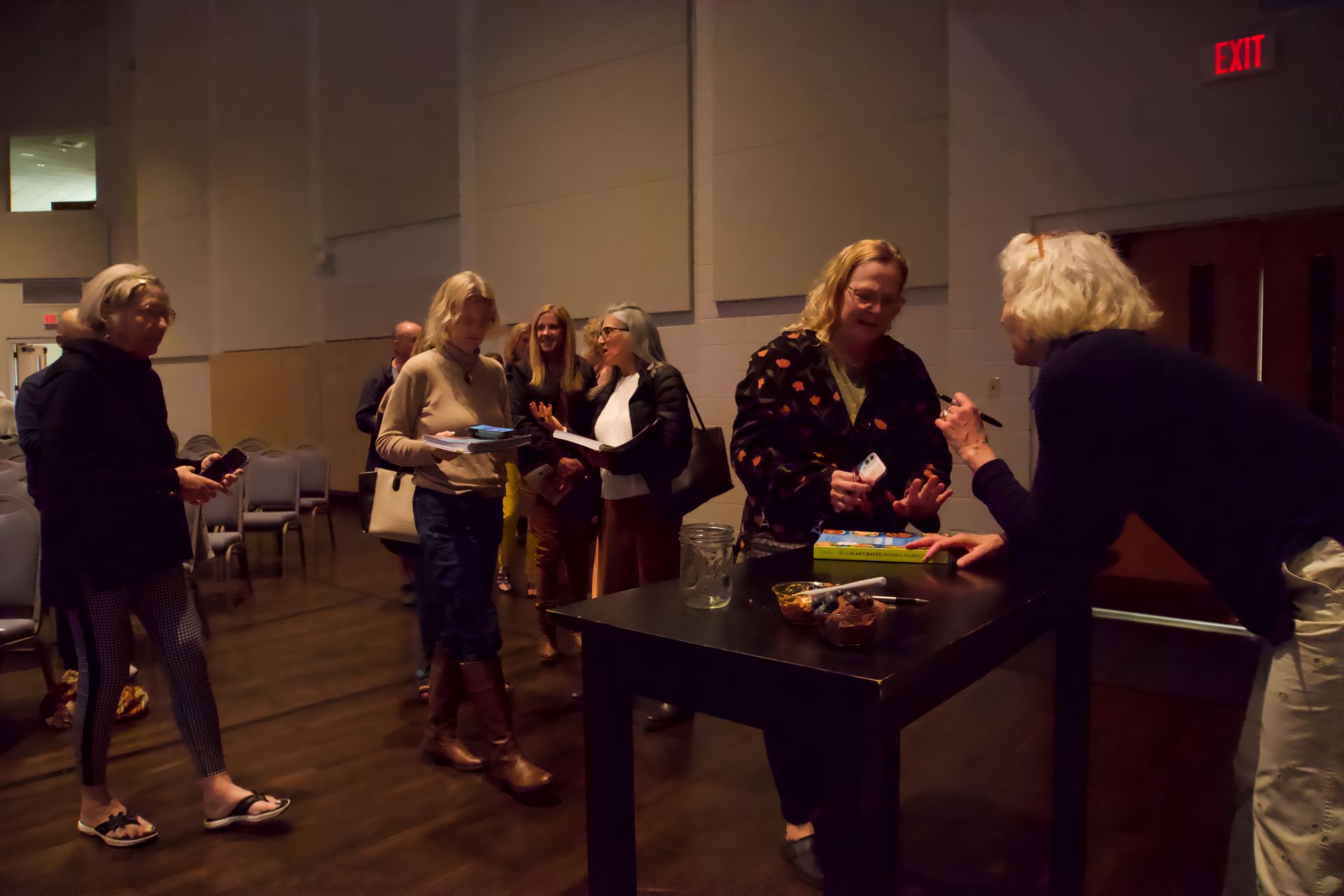 A group of people are standing around a table in a room.