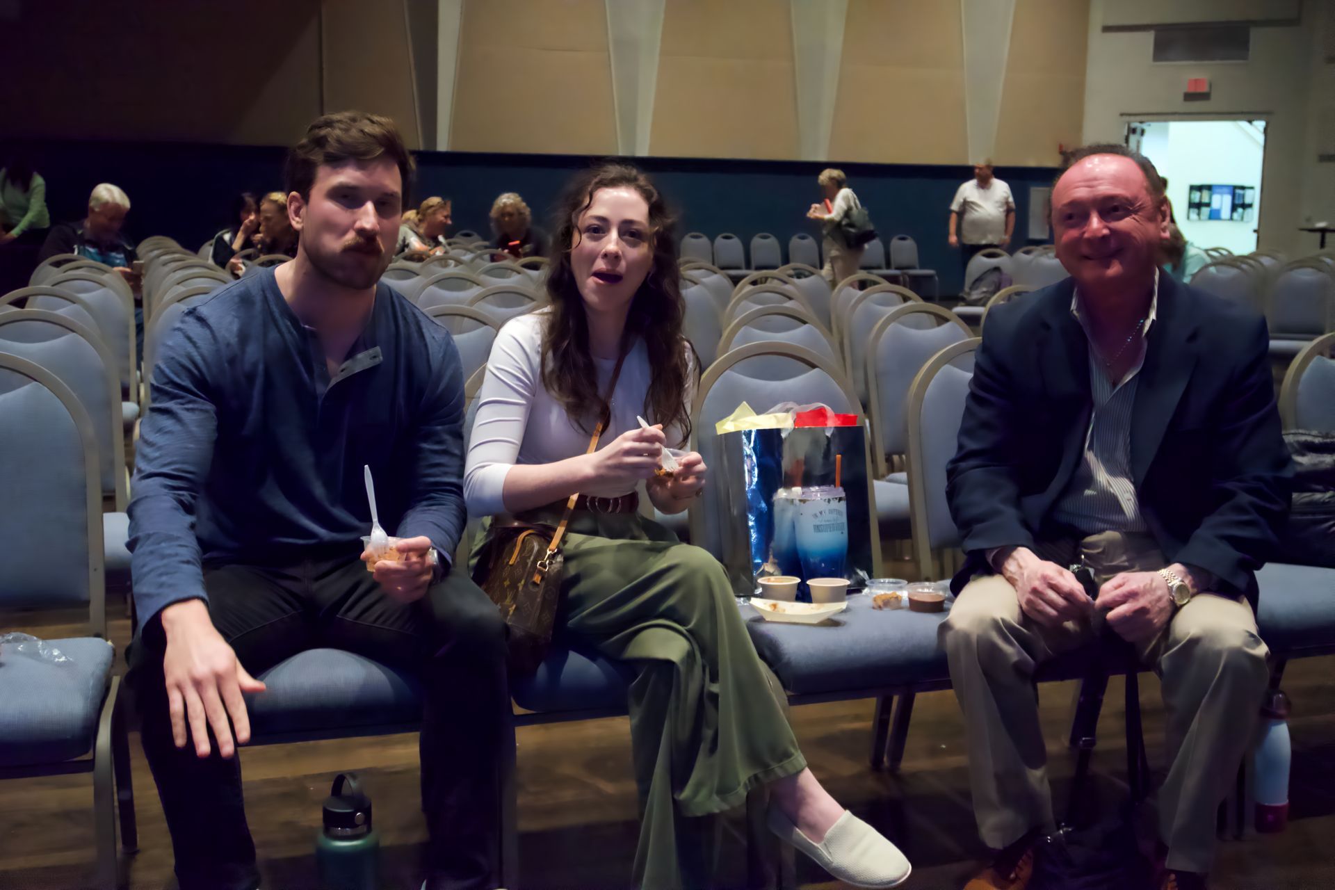 A group of people are sitting in chairs in an auditorium