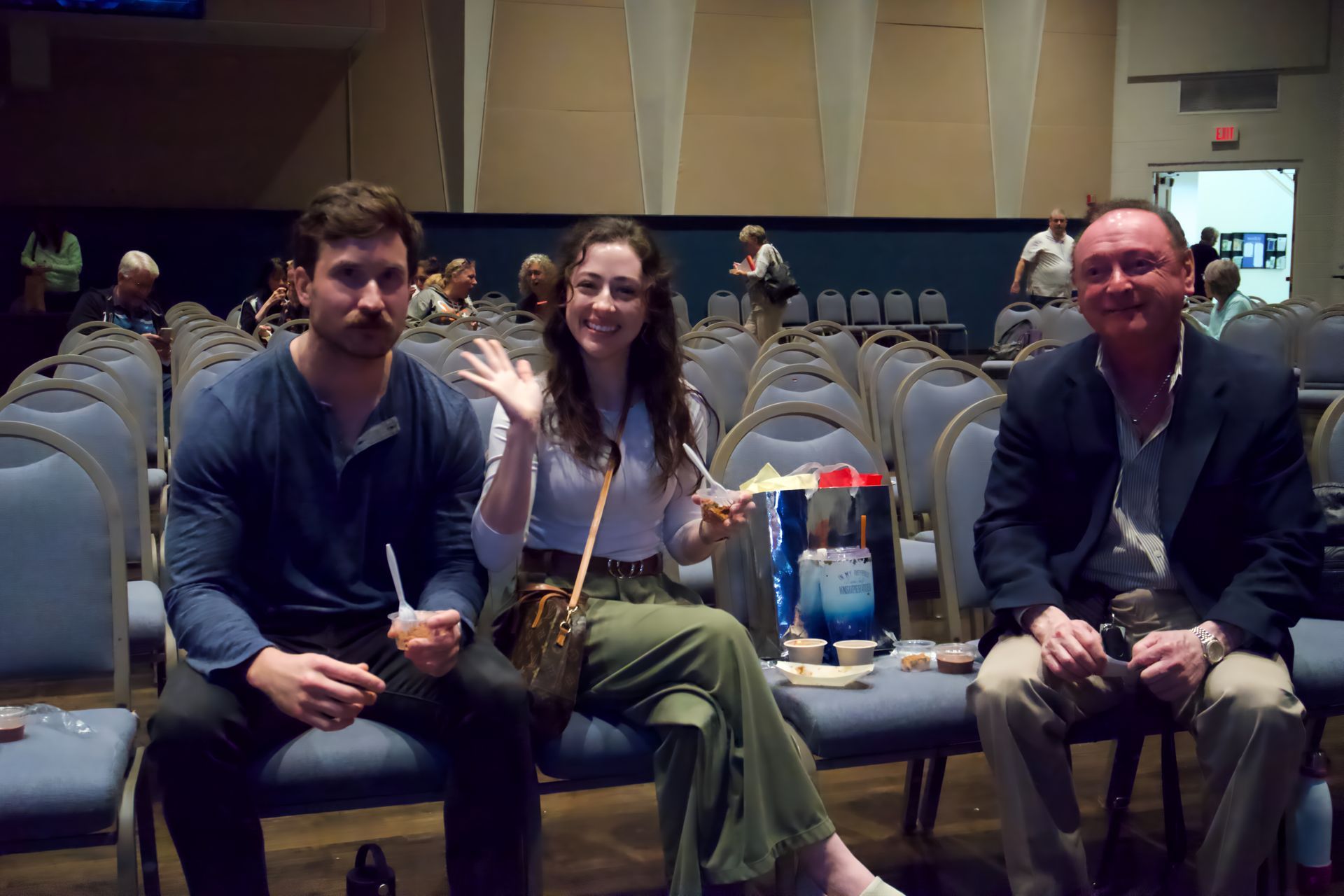 A group of people are sitting in chairs in an auditorium.