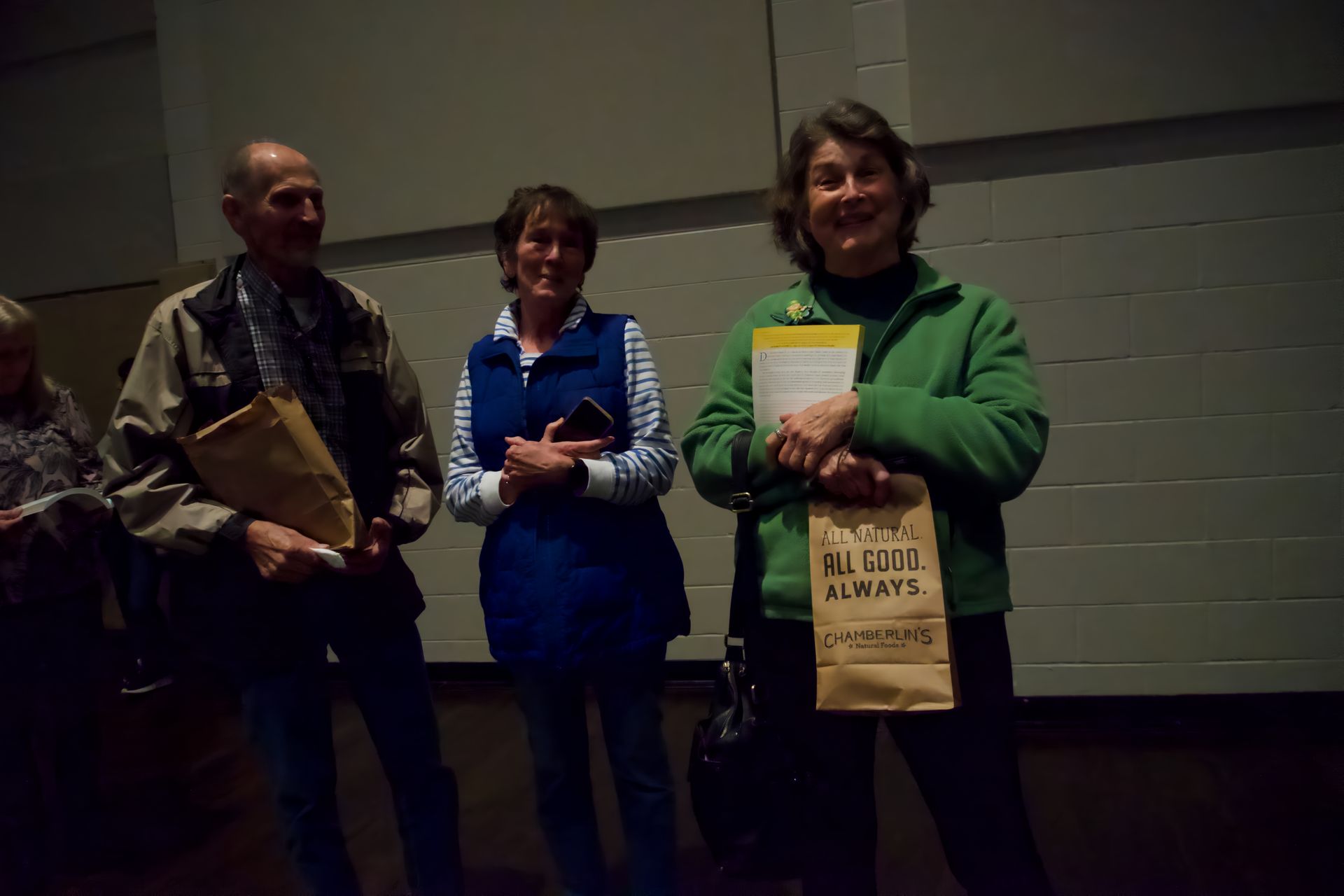 A group of people standing next to each other in a dark room.