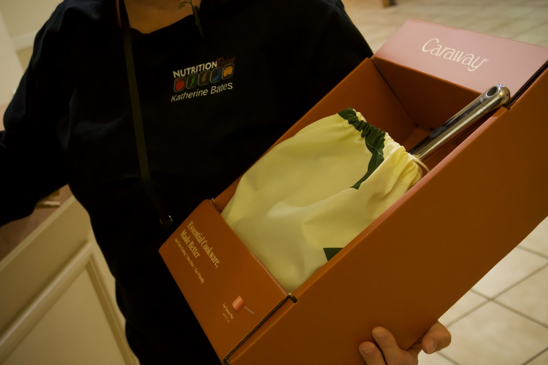 A person holding a cardboard box that says cammy on it