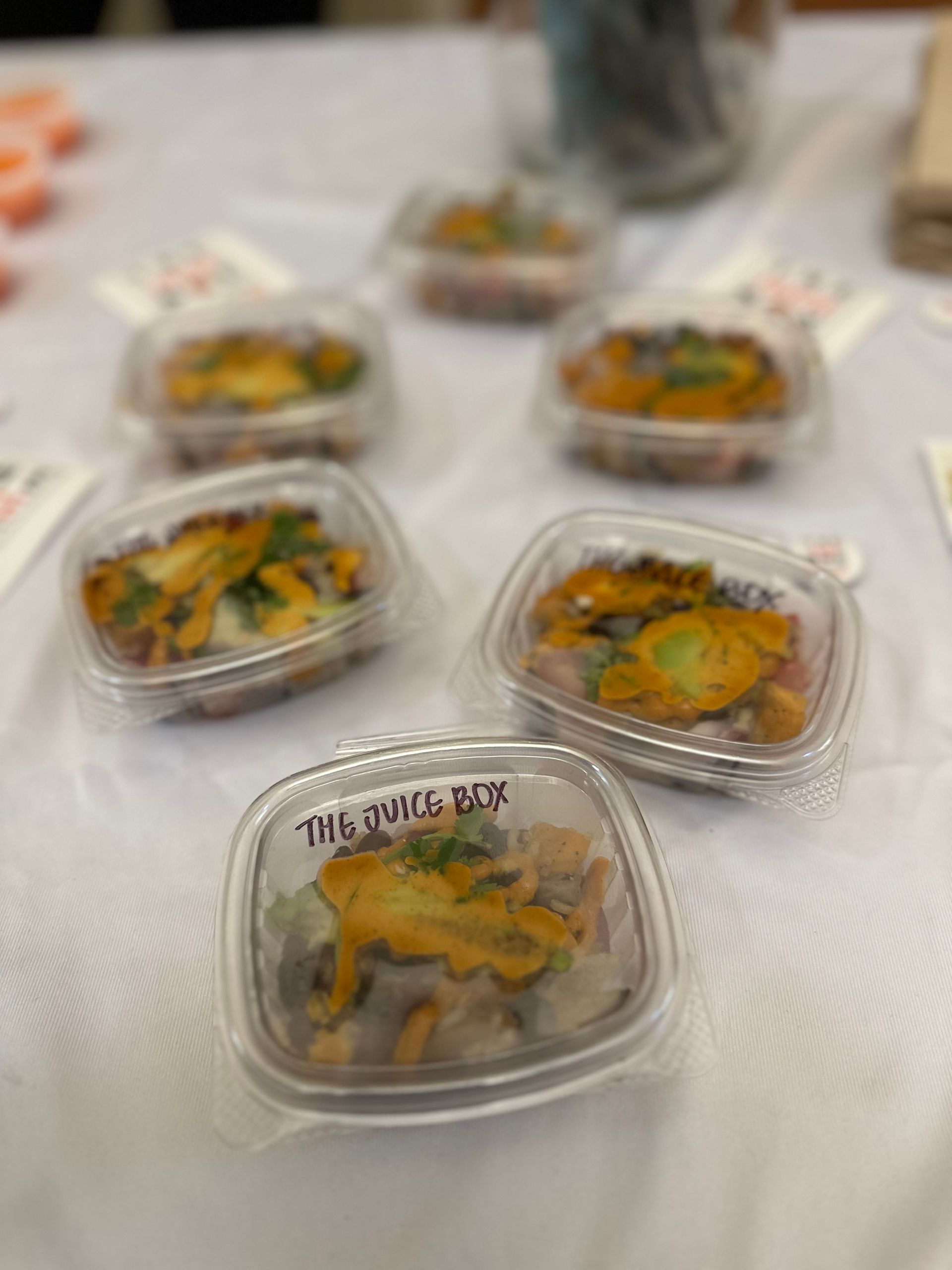 A table topped with plastic containers filled with food.