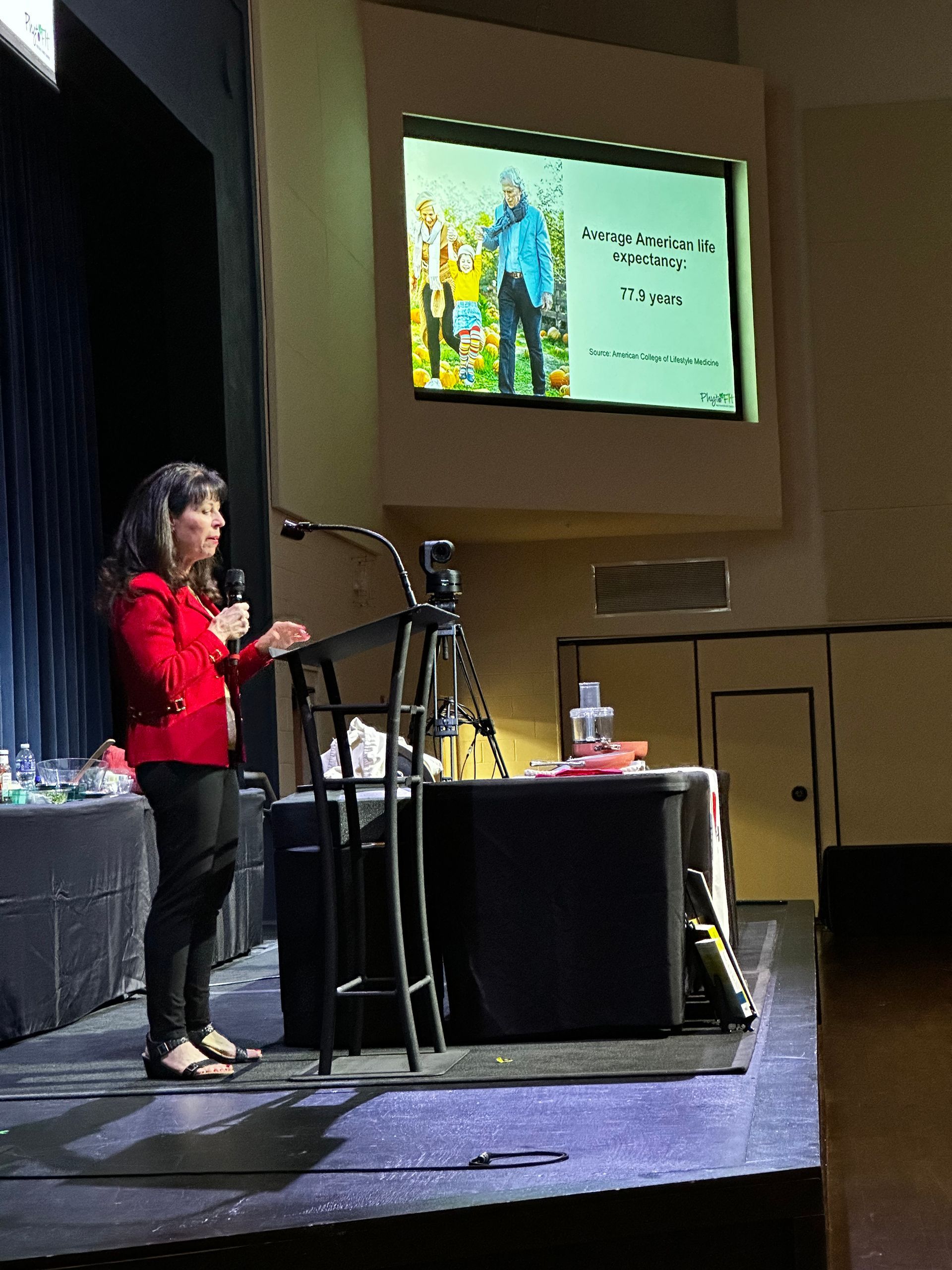 A woman is giving a presentation in front of a large screen