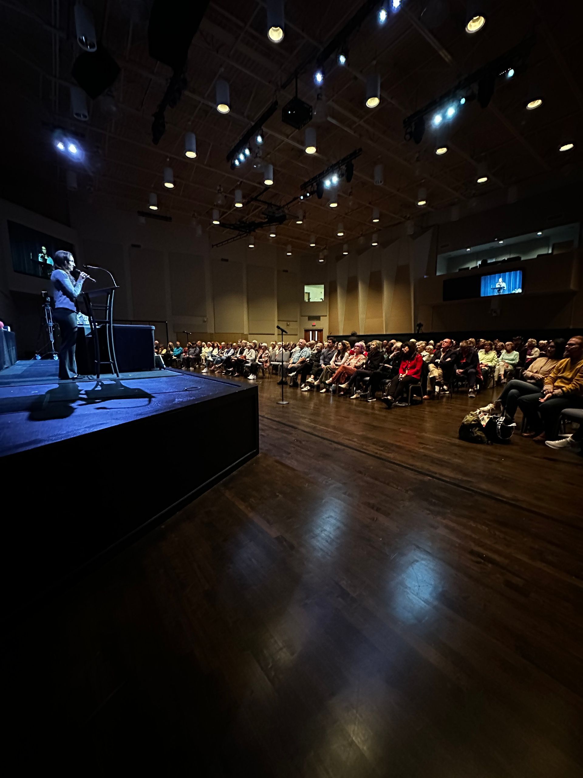 A man singing into a microphone in front of an audience