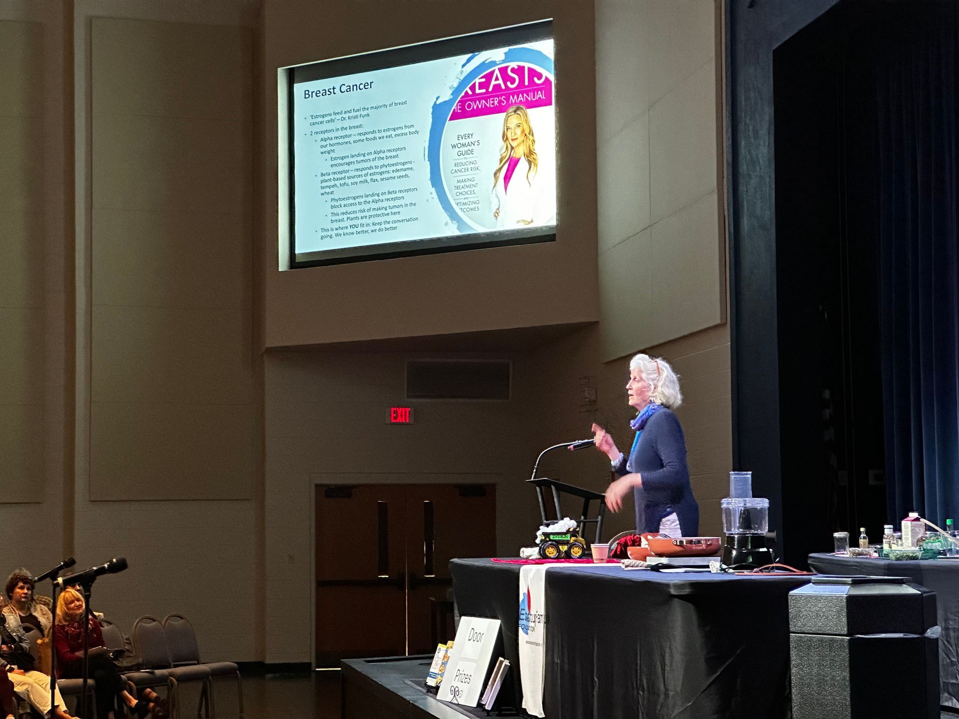A woman is giving a presentation in front of a large screen that says fast