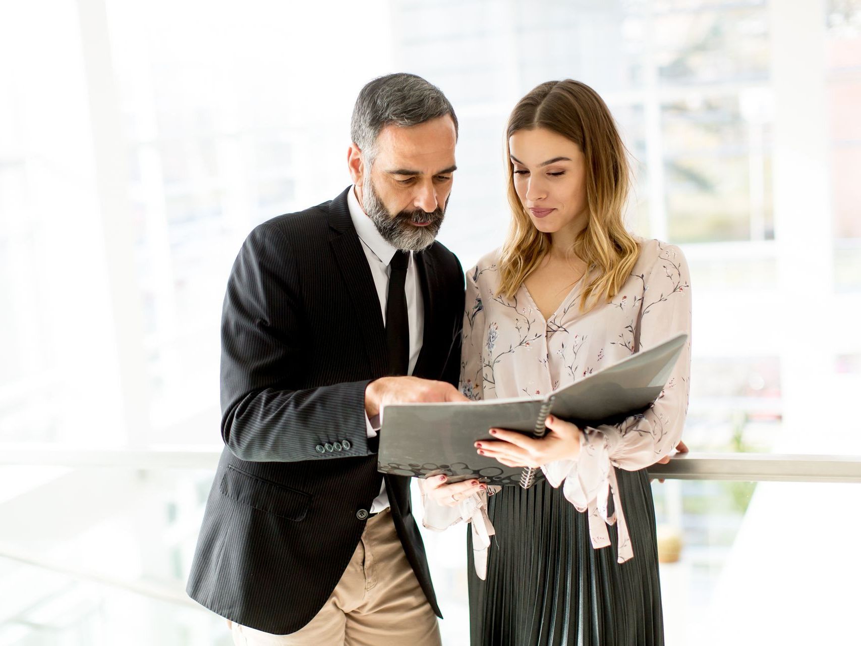 A man and a woman are looking at a laptop together.