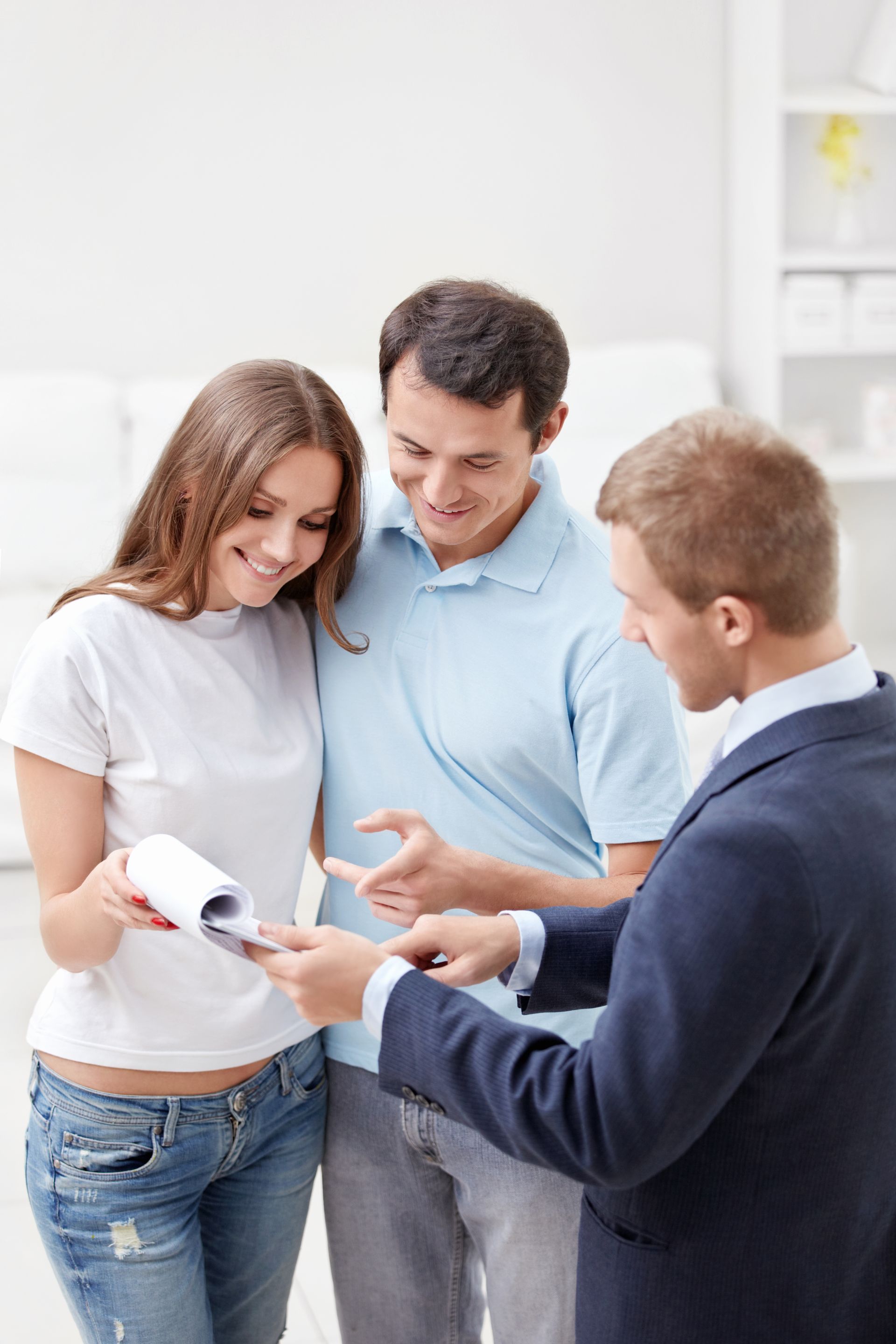A man in a suit is talking to a woman and a man.