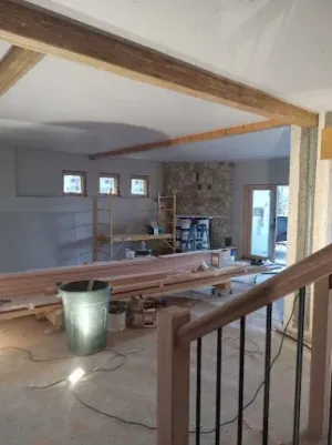 A person holding a baby up in the air indoors near a window, baby smiling.