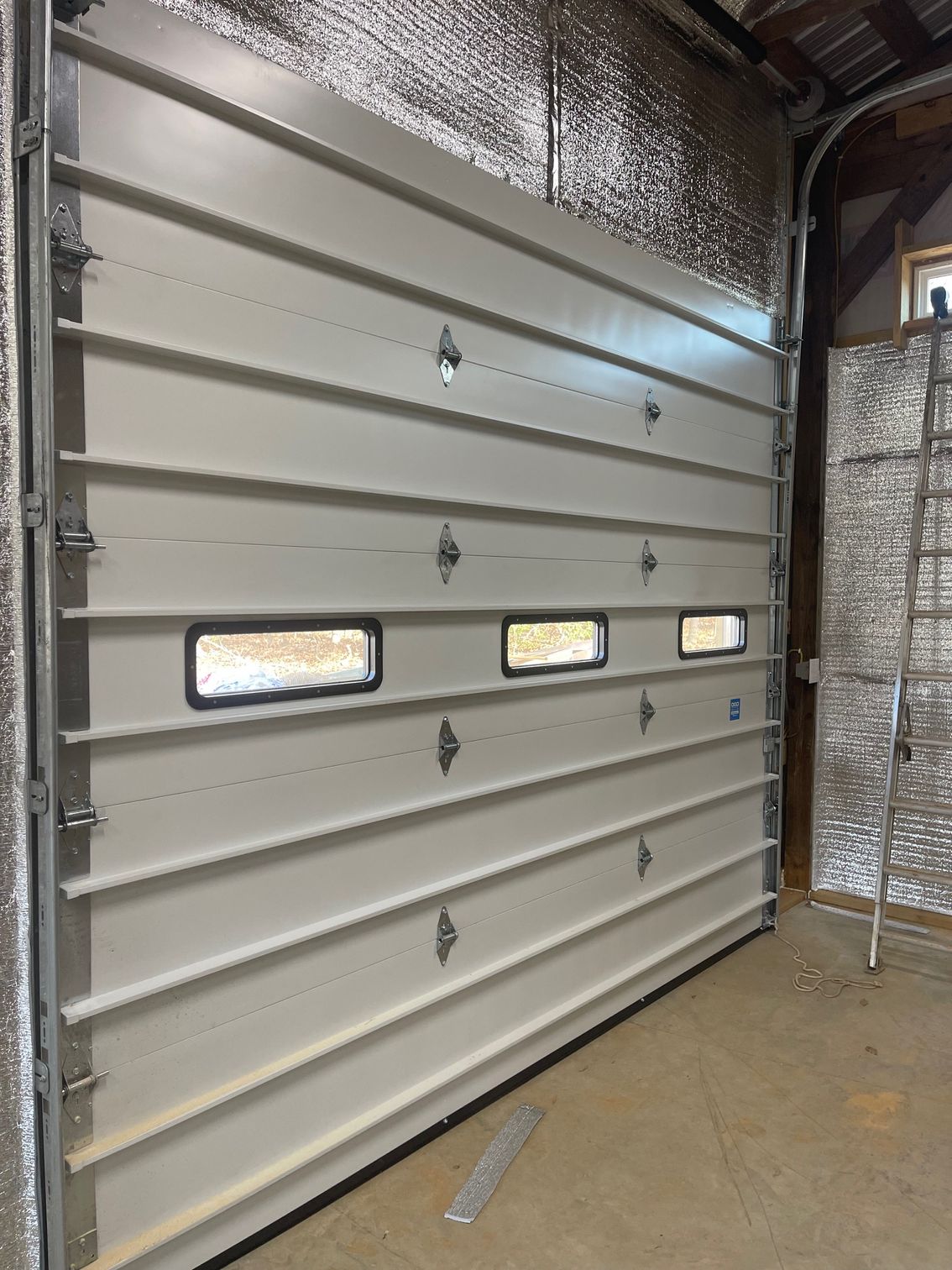 A white garage door with a lot of windows in a garage.