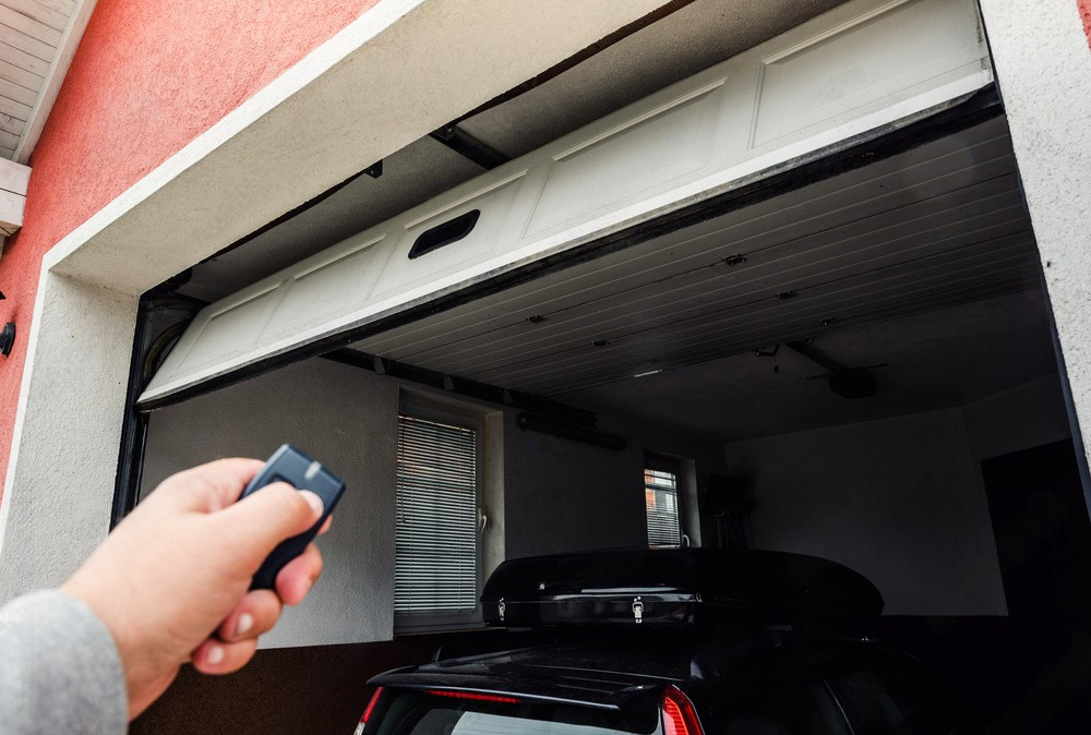 Man using a remote controller to open the garage door.