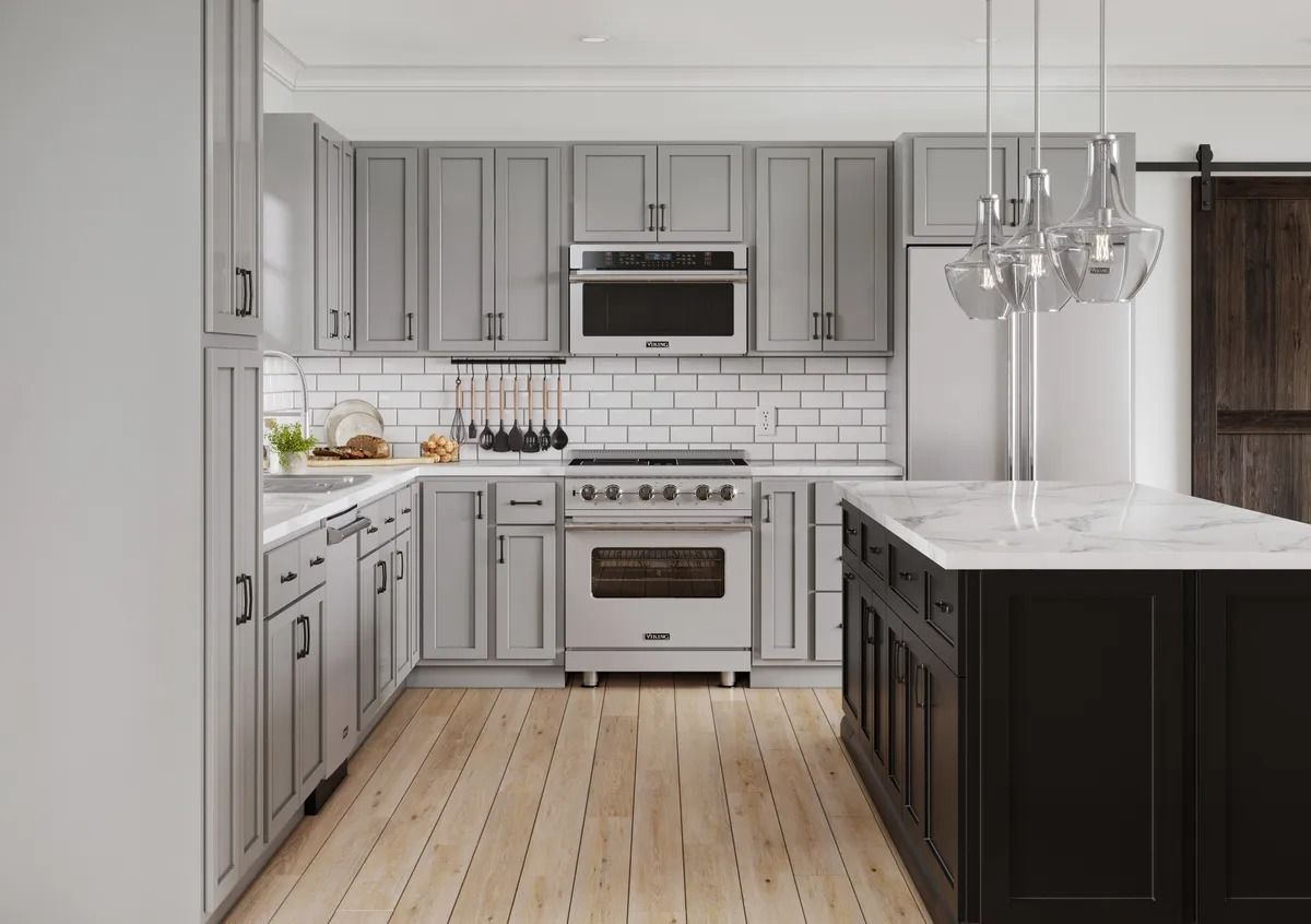 Bright modern kitchen with gray cabinets, white island, stainless appliances, and light wood floors.