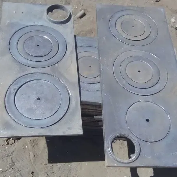 Dos placas de cocina de metal con quemadores circulares y orificio para chimenea, situadas al aire libre.