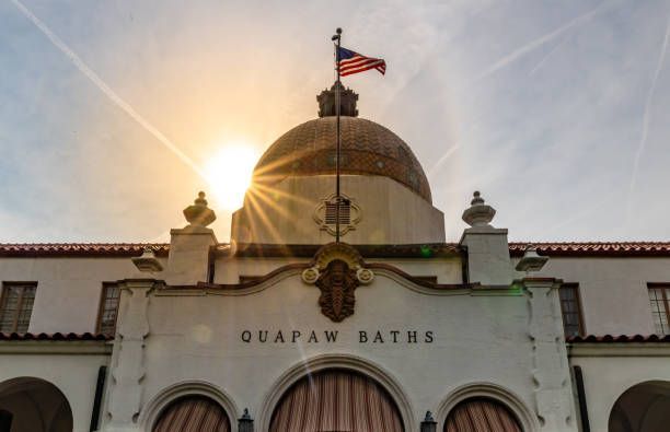 Quapaw Baths building with dome, American flag, and sunburst in the sky.