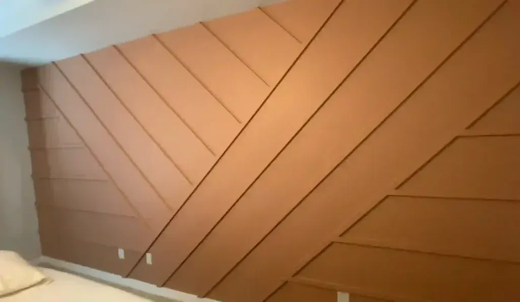 Brown wood accent wall with angled and horizontal designs.