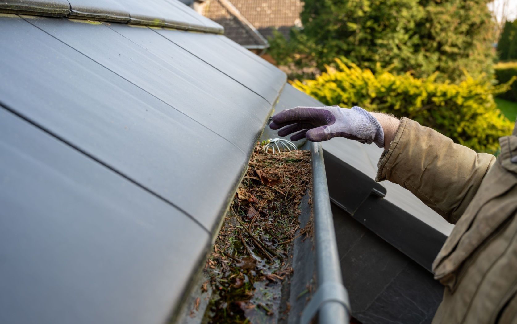Professional cleaner meticulously wiping down a grimy window frame using a microfiber cloth, restoring its clarity and shine.